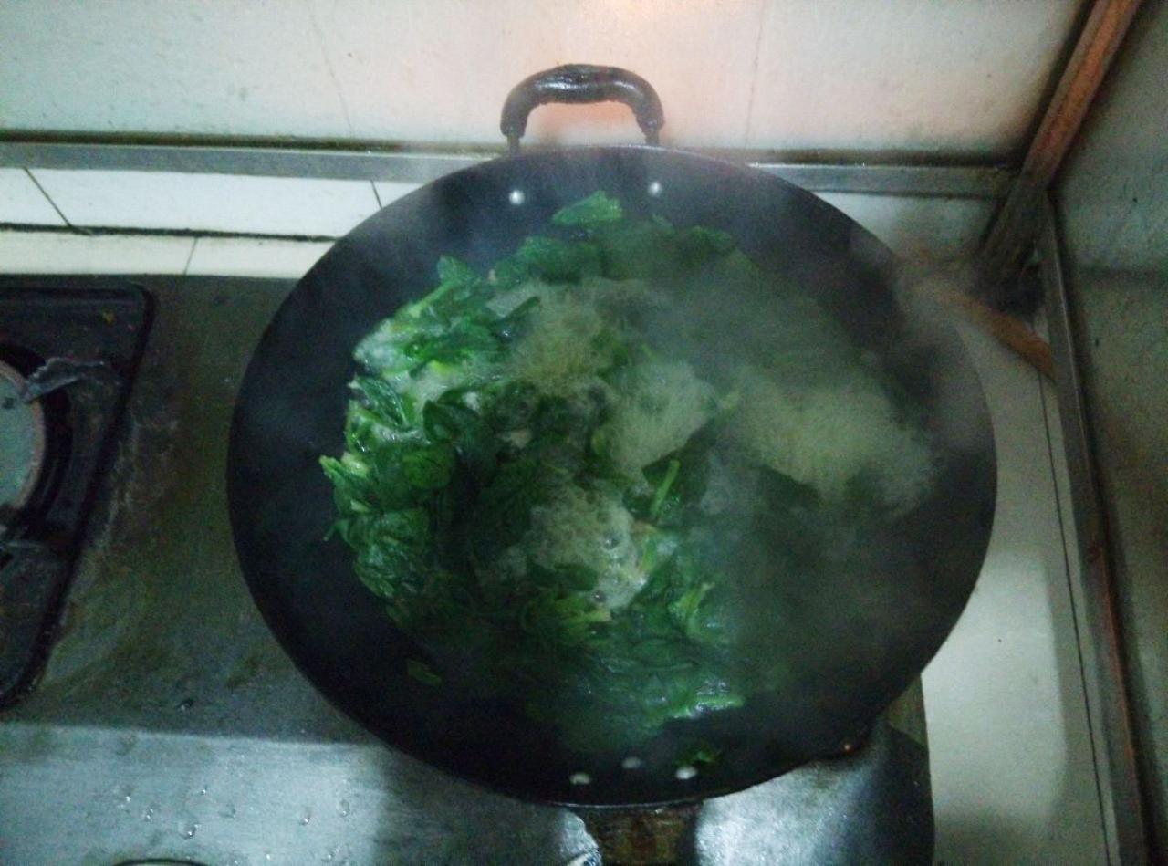 正在锅中用开火烫的菠菜