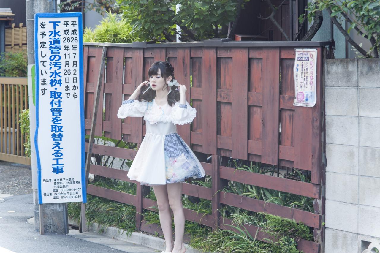 近衛りこ站在公告牌右，双手拉着马尾