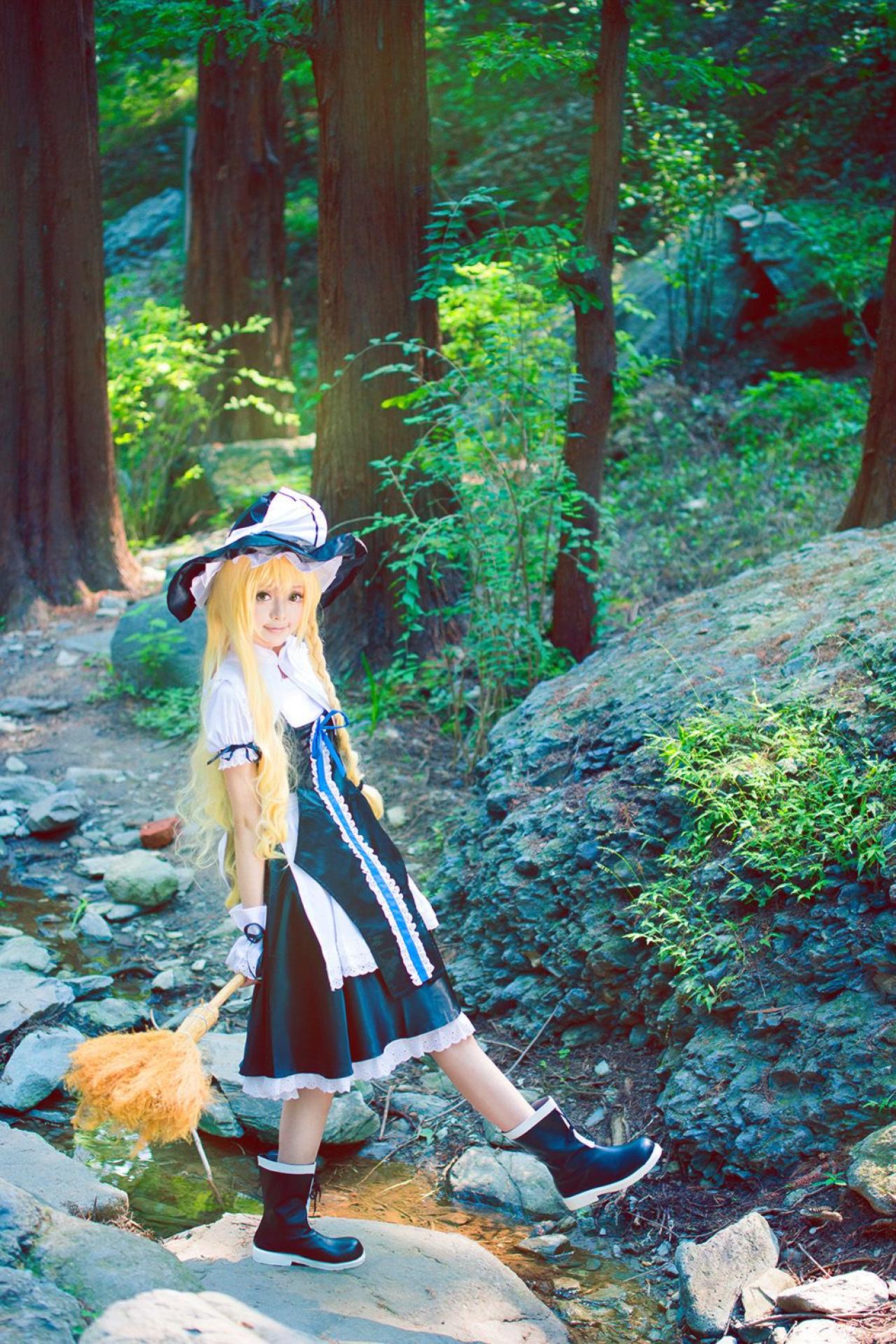 雨扮演雾雨魔理沙双手背后握着扫把，正迈出一步