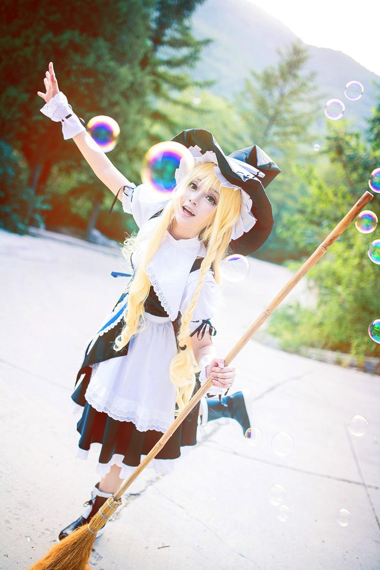 雨扮演雾雨魔理沙，左手握着扫把，右臂抬起，追赶飞舞的气泡的姿势