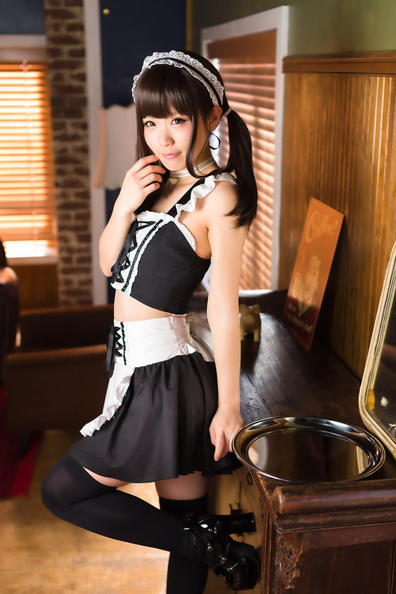 倉坂くるる站着靠在案几旁的侧面照