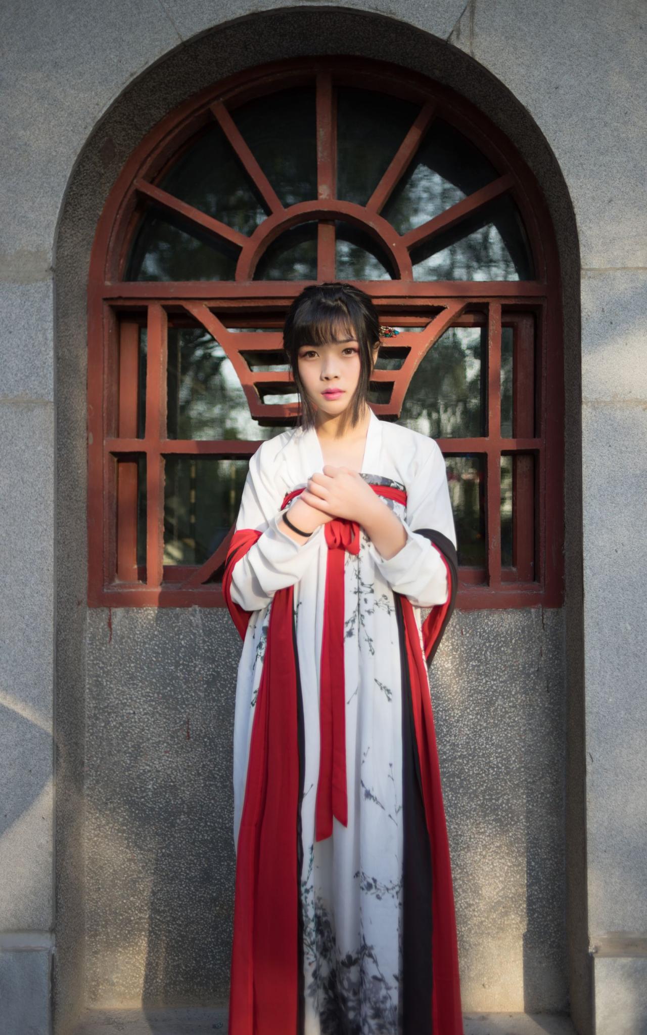 霓君双手叠放在胸前站在窗前