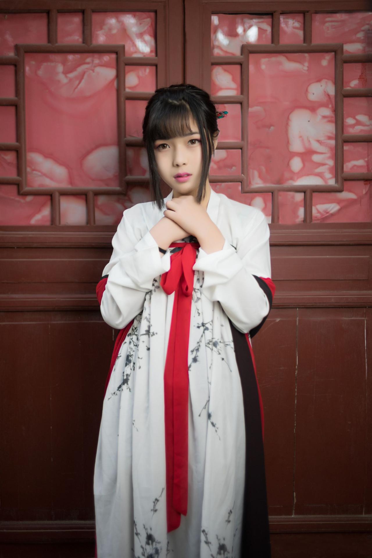 霓君双手叠放在领口站在雕花木门前