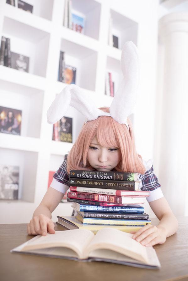 まゆふぁむ戴着兔耳朵扒在一叠书上，嘟嘴卖萌