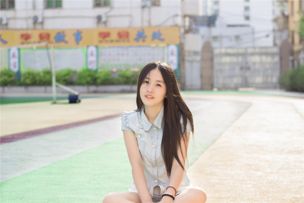 陈婕盘腿坐在跑道上，横幅照