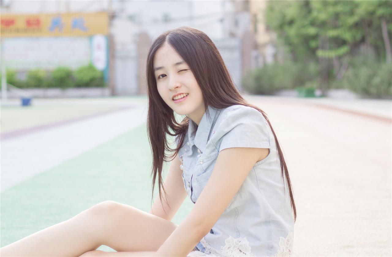 陈婕侧身坐在跑道上，眨眼卖萌