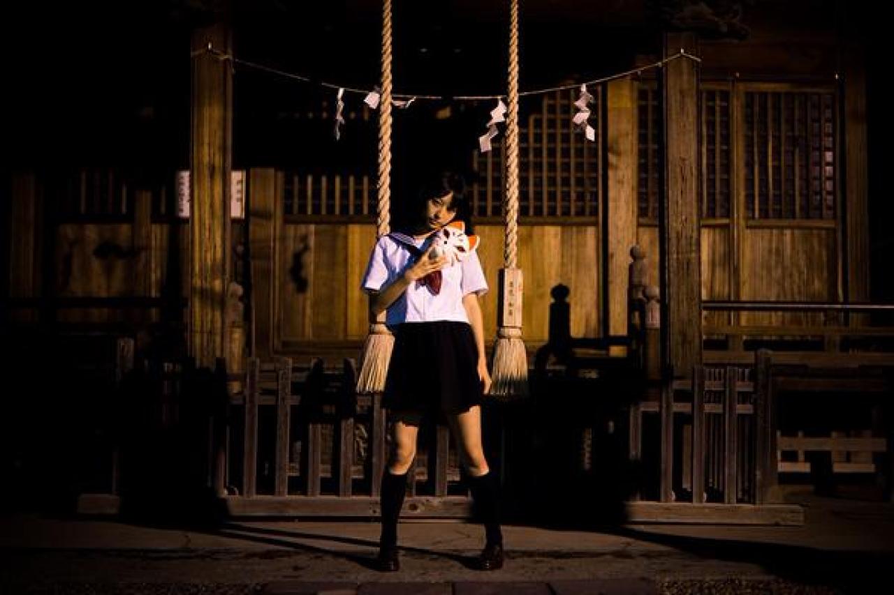 猫守ざーにゃ扮阎魔爱右手拿着面具贴在肩部，站在神社门前