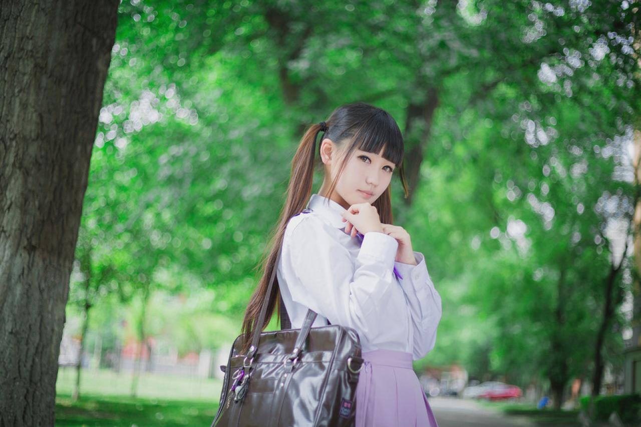 紫色制服萌妹子挎着通勤包，双手放在领口
