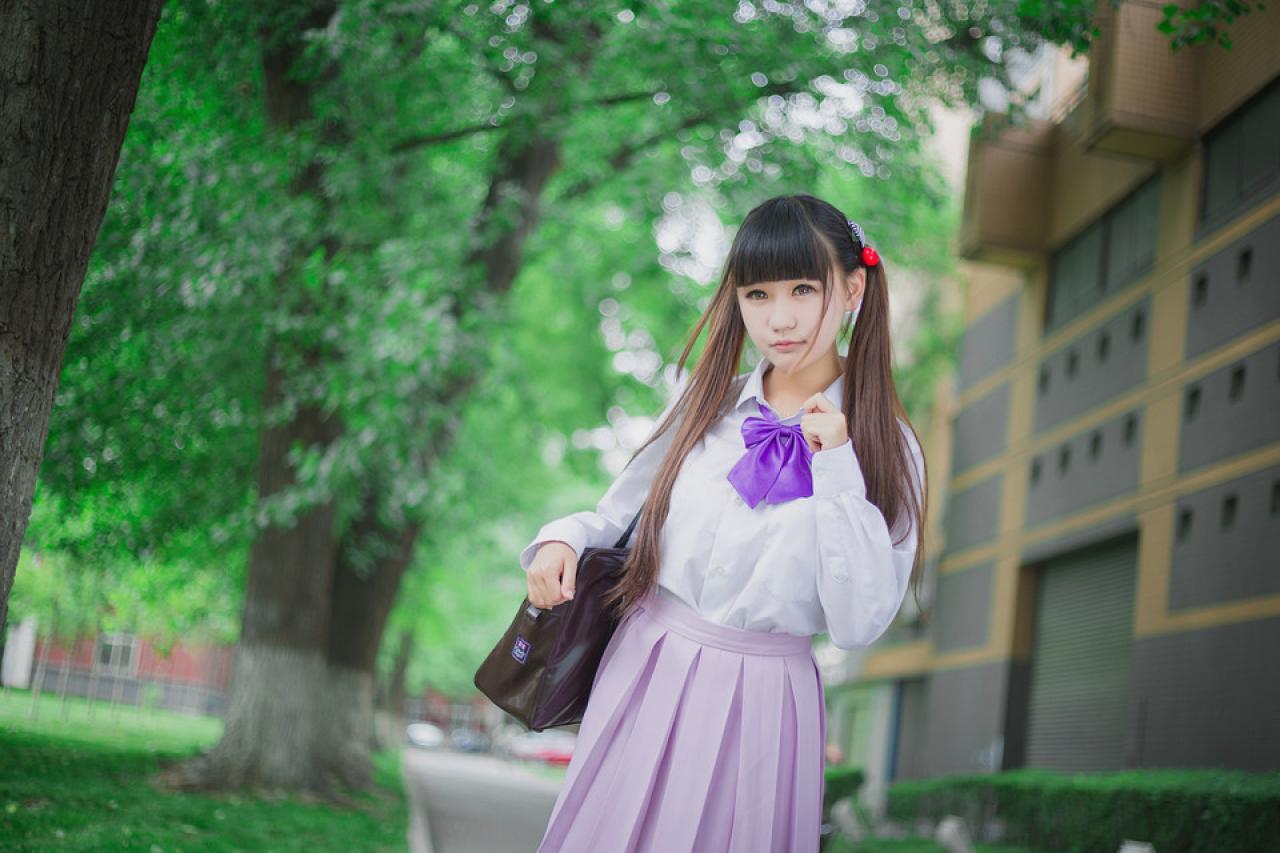 紫色制服萌妹子挎着通勤包，左手抬到领口