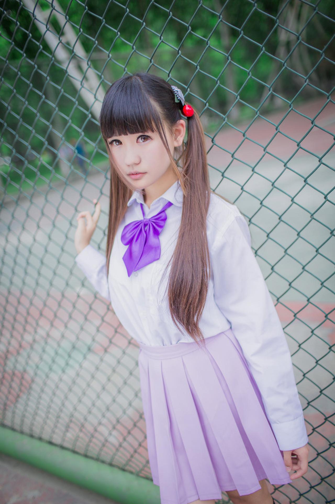 紫色制服萌妹子站在体育场的铁网旁