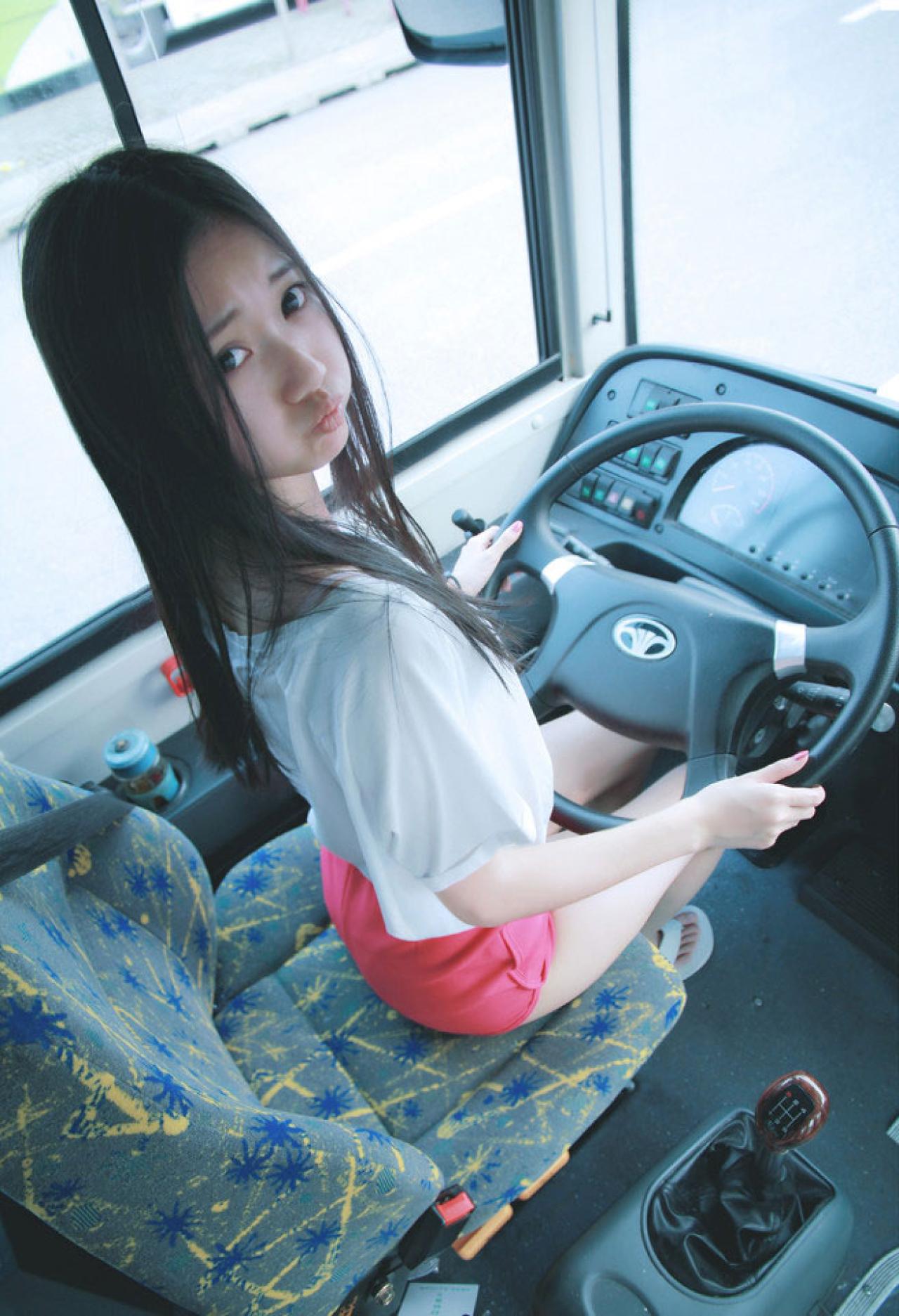 小Q嘟嘴卖萌坐在公交车上，双手握着方向盘，嘟嘴卖萌
