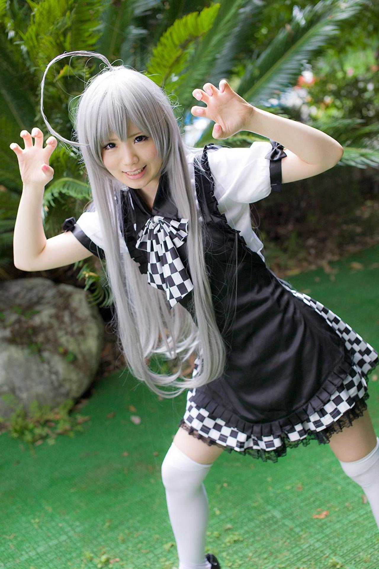 倉坂くるる双手五指弯曲变“爪”，倾斜身子咧嘴坏笑的神情