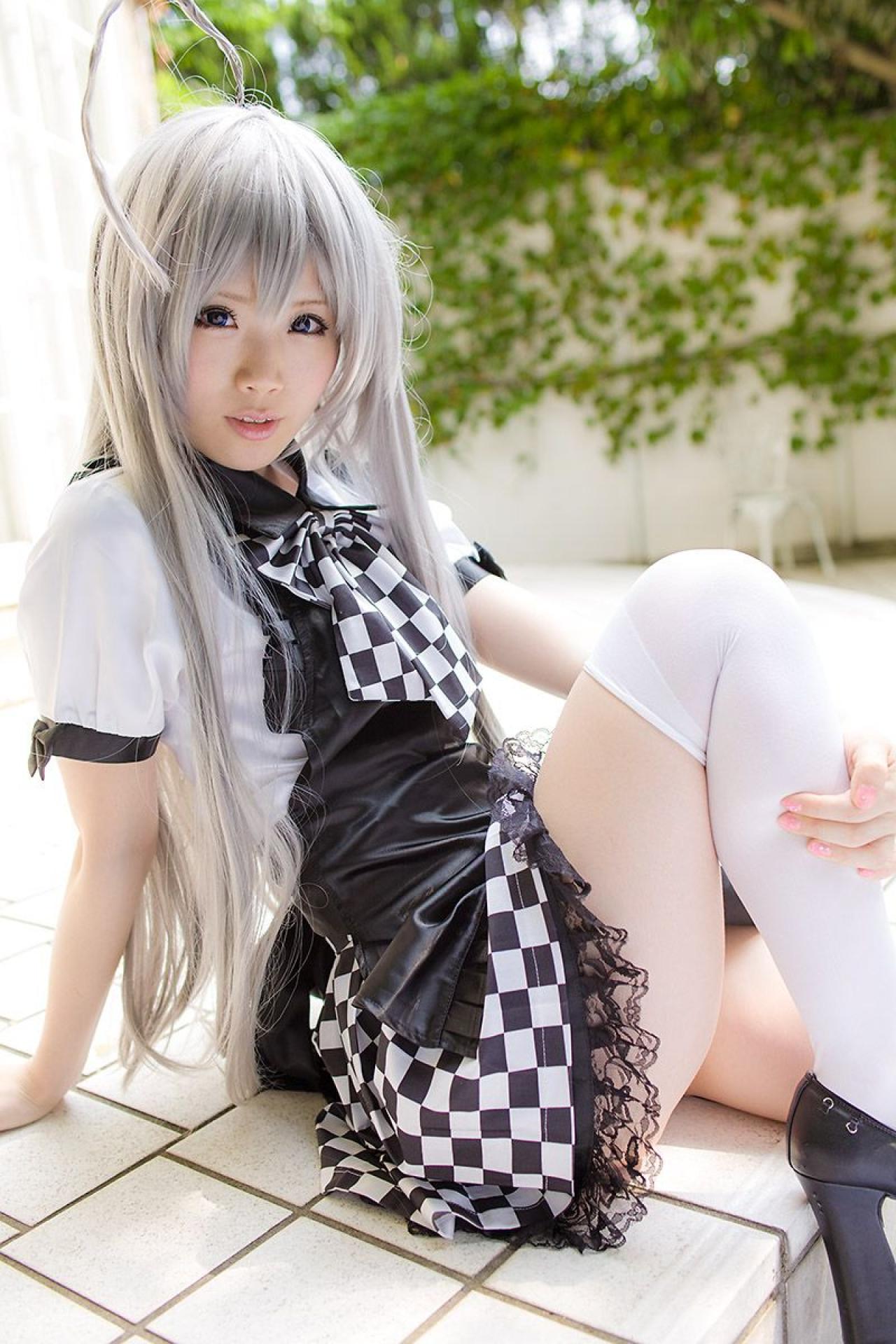 倉坂くるる侧身坐在地上，右手撑着身子，左臂弯曲，抱着右腿