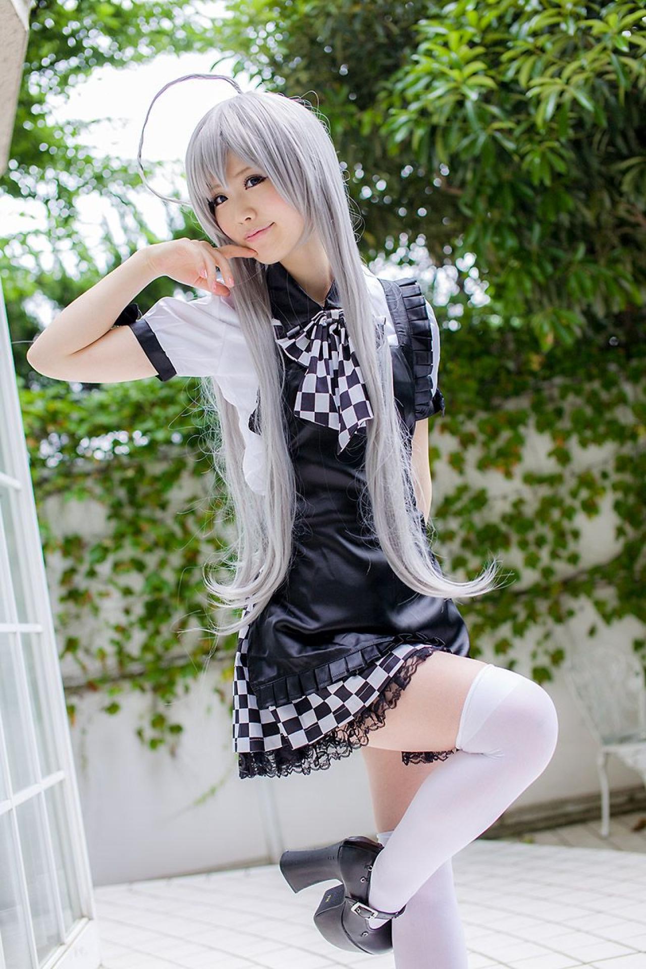 倉坂くるる右臂弯曲，食指贴着嘴角，左臂贴着身子