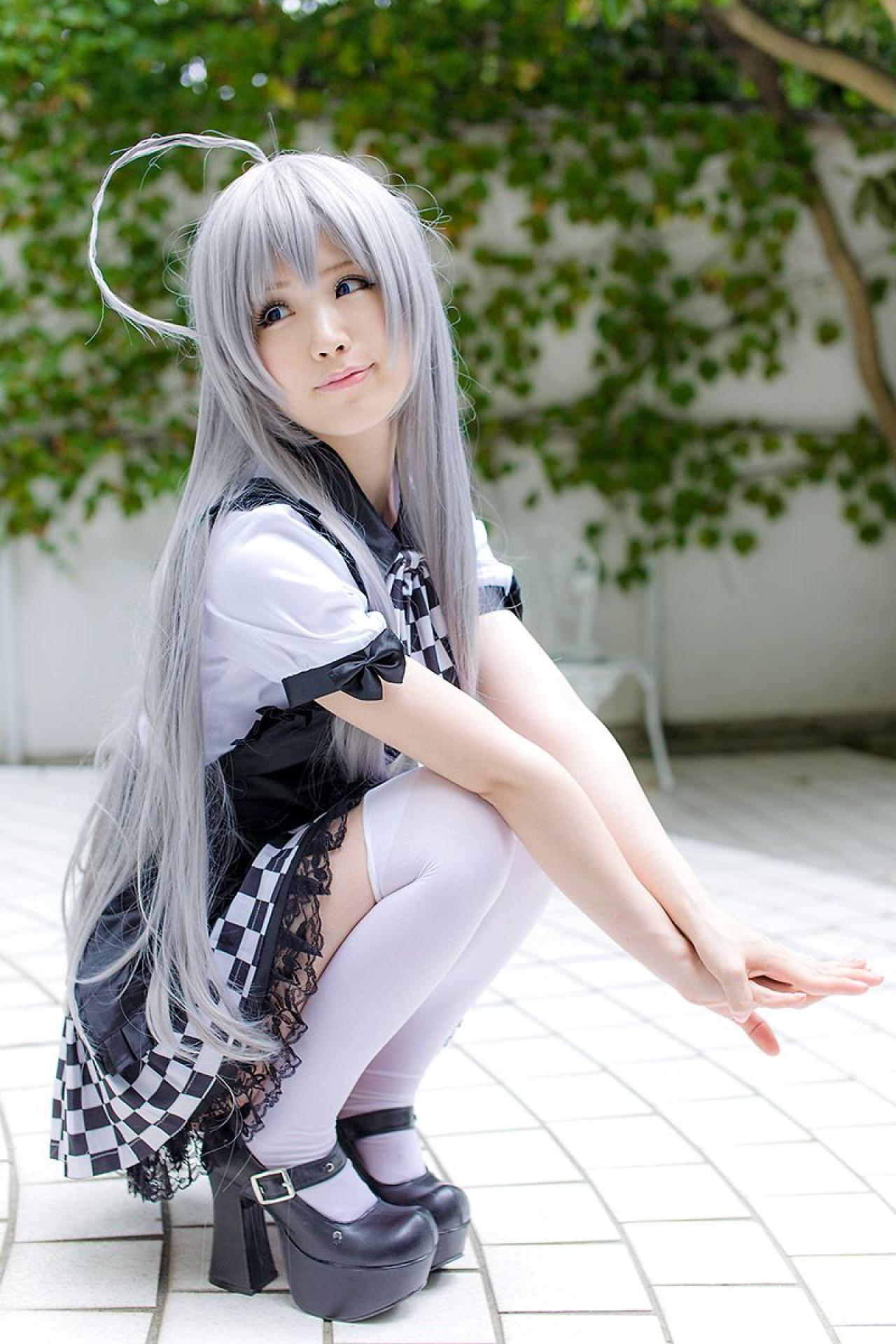 倉坂くるる双臂叠放在膝盖上，手掌相叠，侧身回眸仰望天空