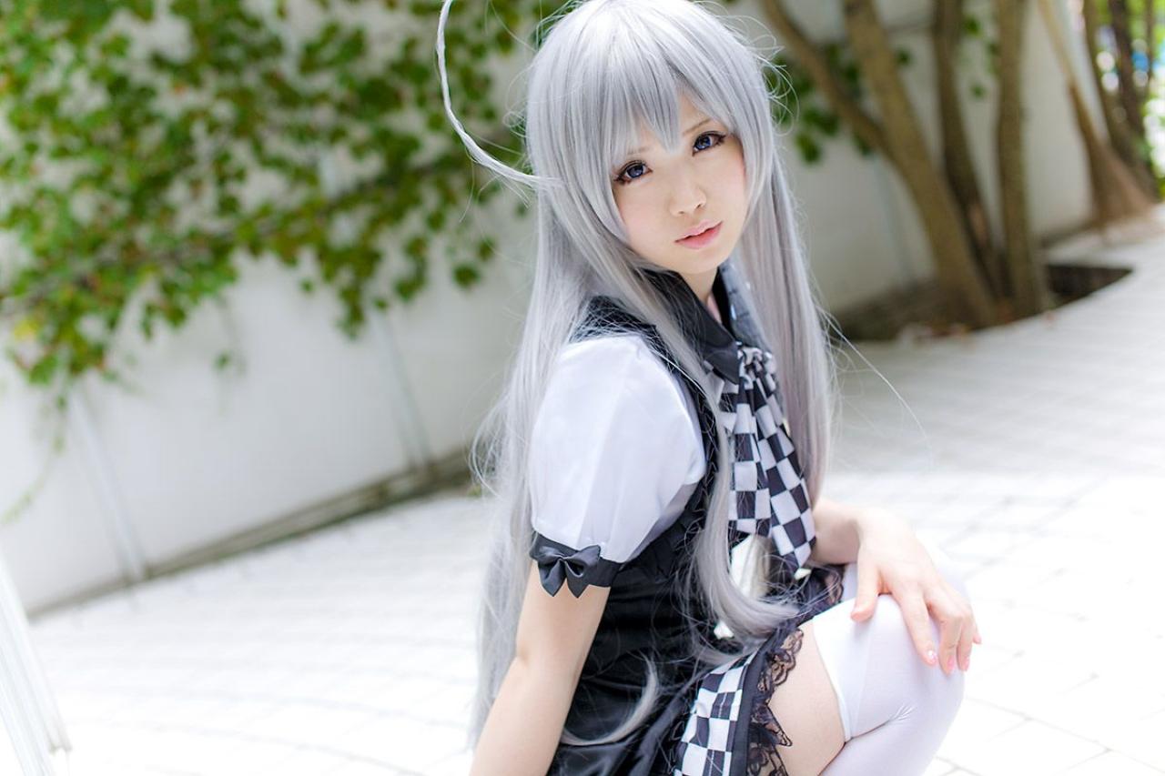 倉坂くるる蹲着，右手搭在地上，左臂放在膝盖上，侧身回头歪着头，凝望