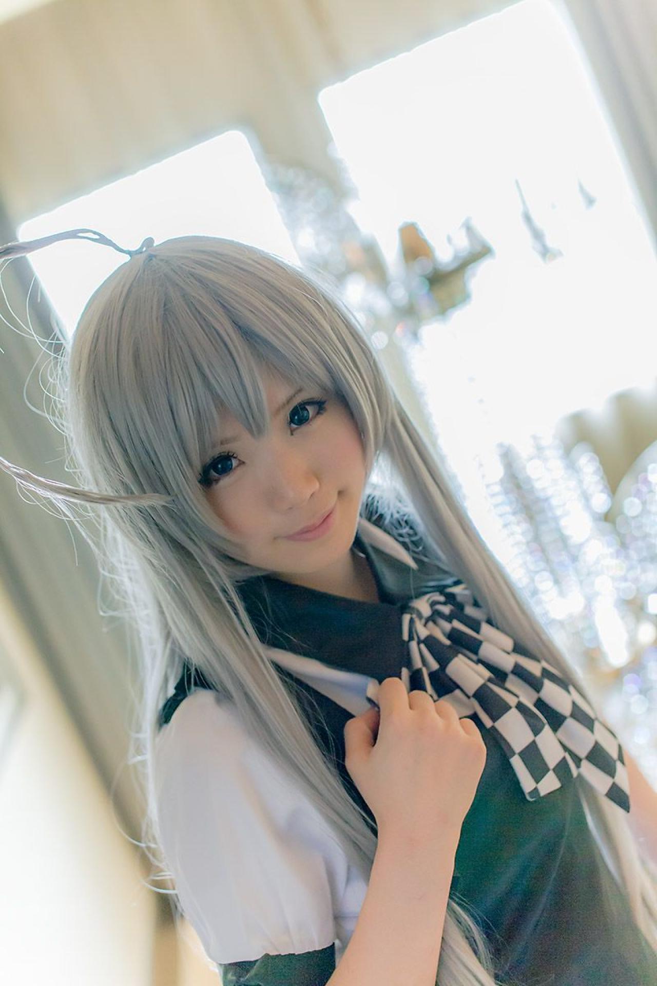 倉坂くるる在室内，右手放在领结上，微笑