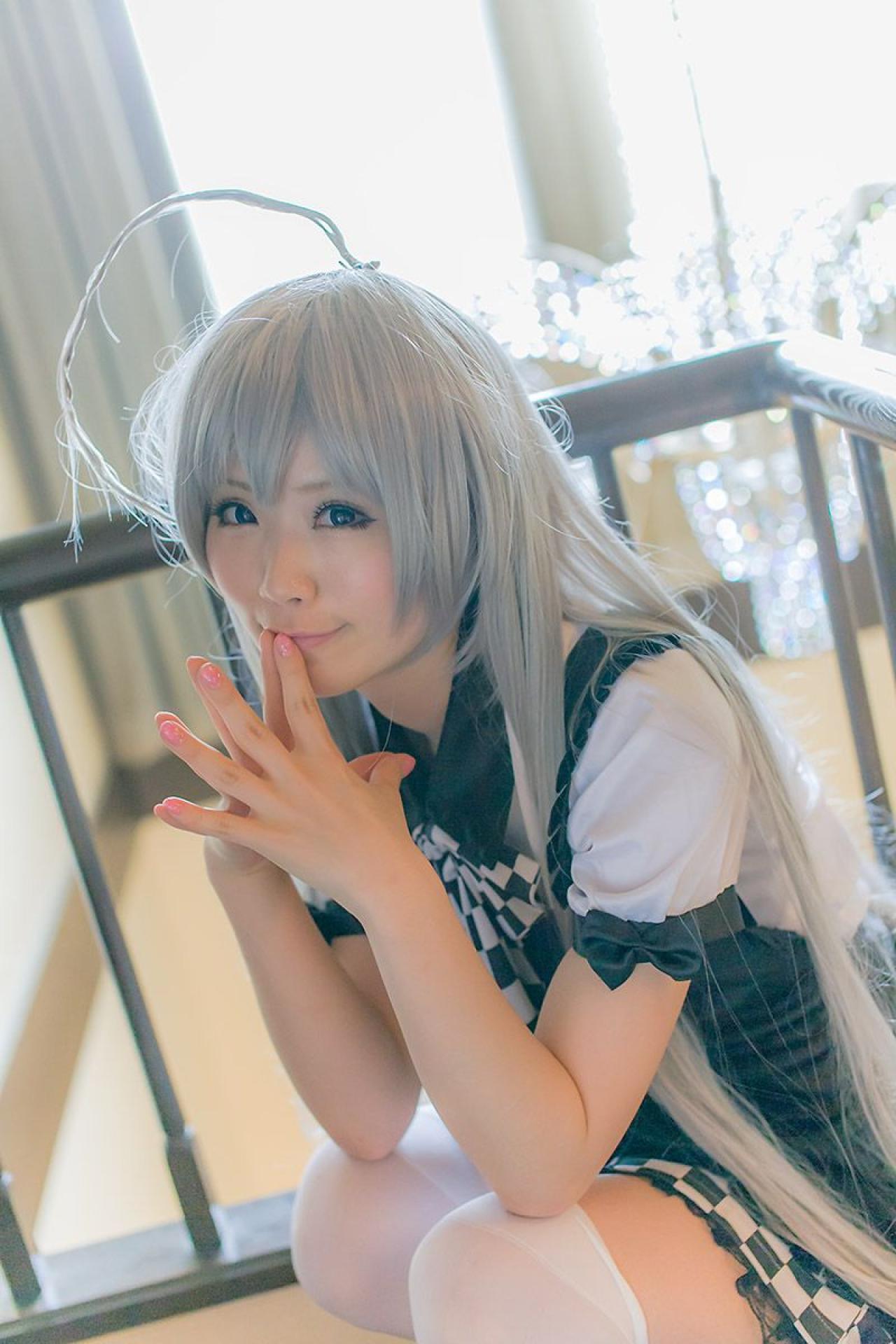 倉坂くるる双手五指相抵，贴在嘴角，蹲在楼梯的休息平台上