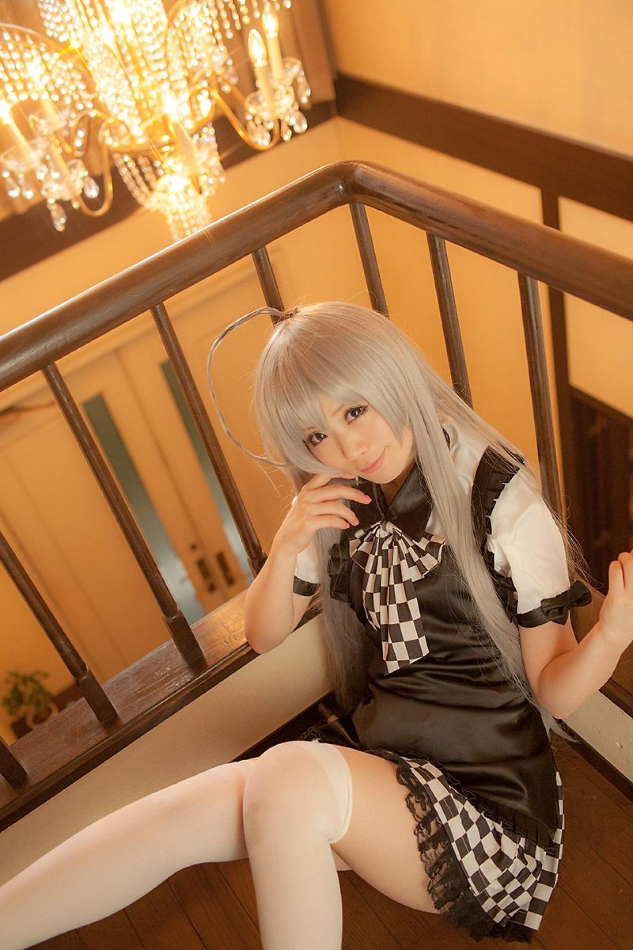 倉坂くるる靠在楼梯的拐角处，右手轻抵刘海儿，左手贴着栏杆