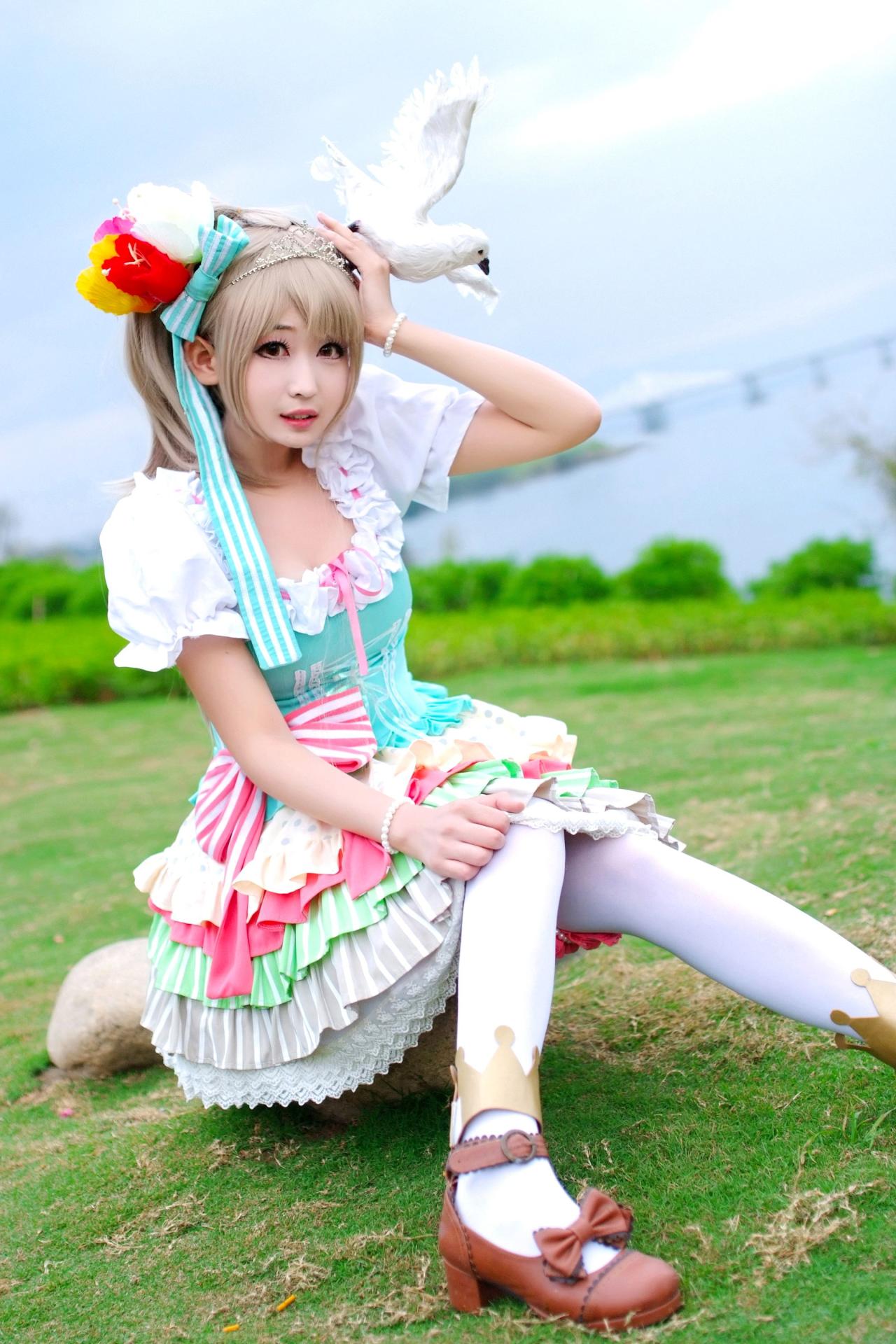 灼漪漪扮南小鸟坐在草地，将鸽子贴在头发上