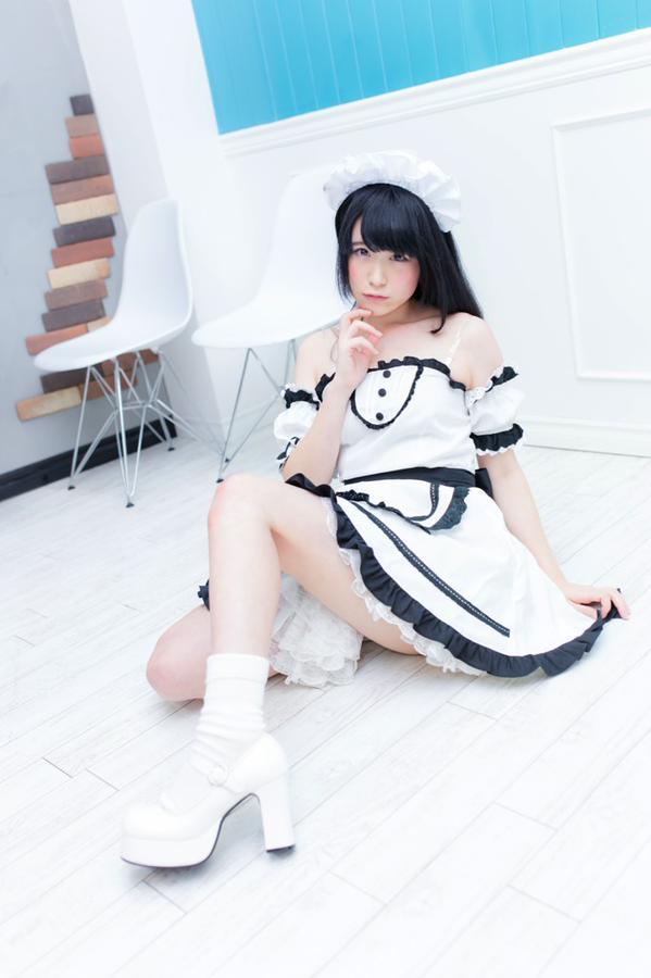 モニ子穿着女仆装坐在地板上，左手拉着裙摆，右手的手指轻抵下巴