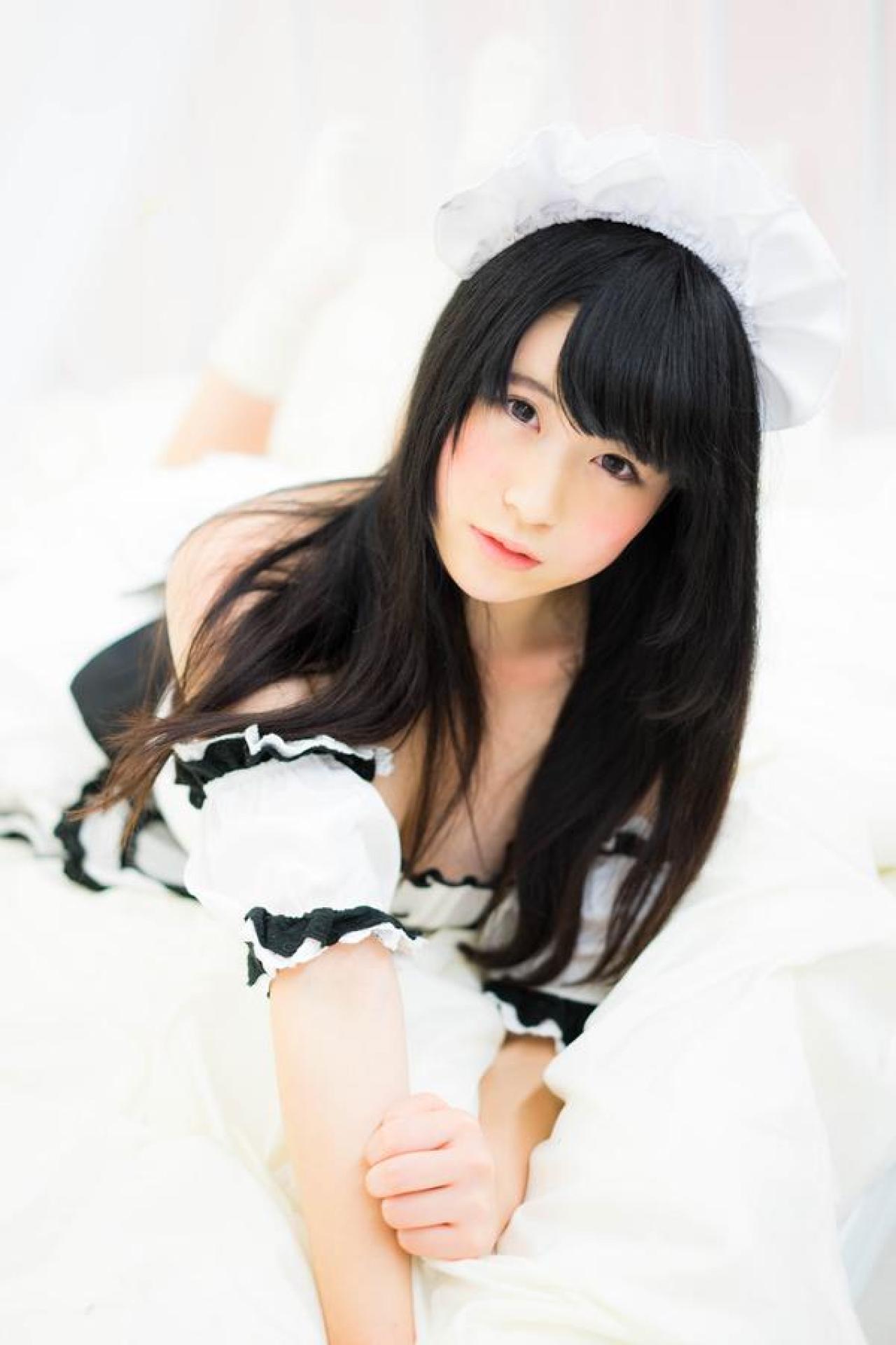 モニ子翘着双腿，扒在床上，歪着头凝望镜头