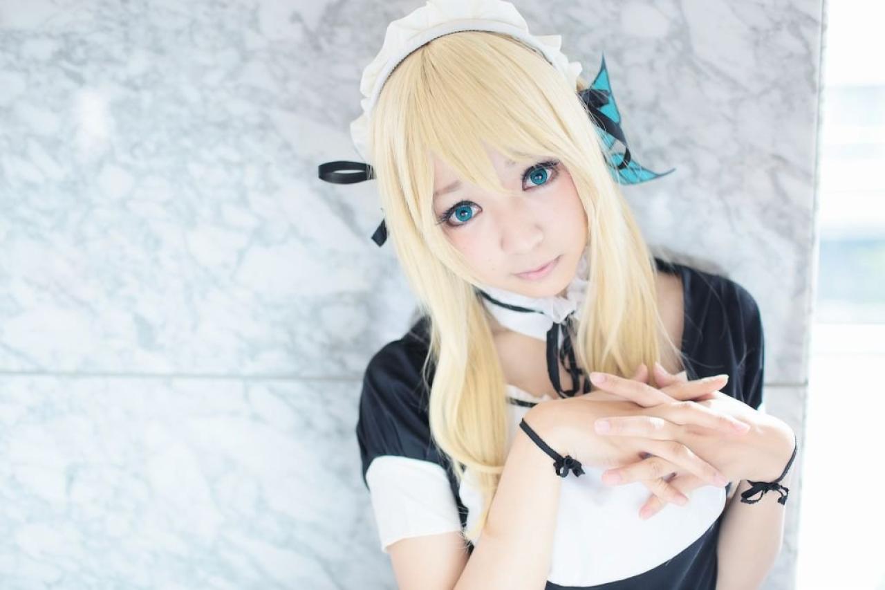 さとう扮柏崎星奈五指交叉，歪着头站在立柱旁，上半身照