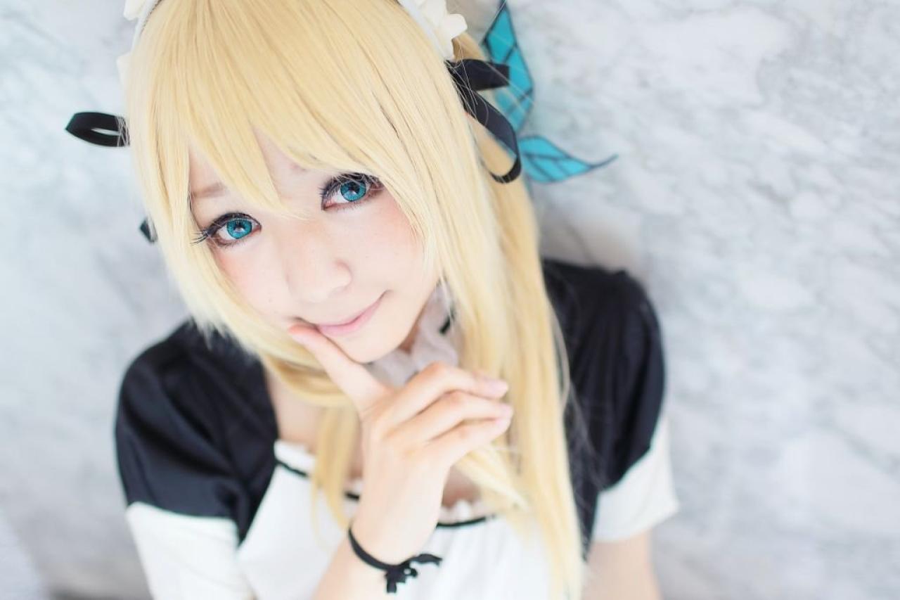 さとう扮柏崎星奈右手食指抵着嘴角，微笑的表情