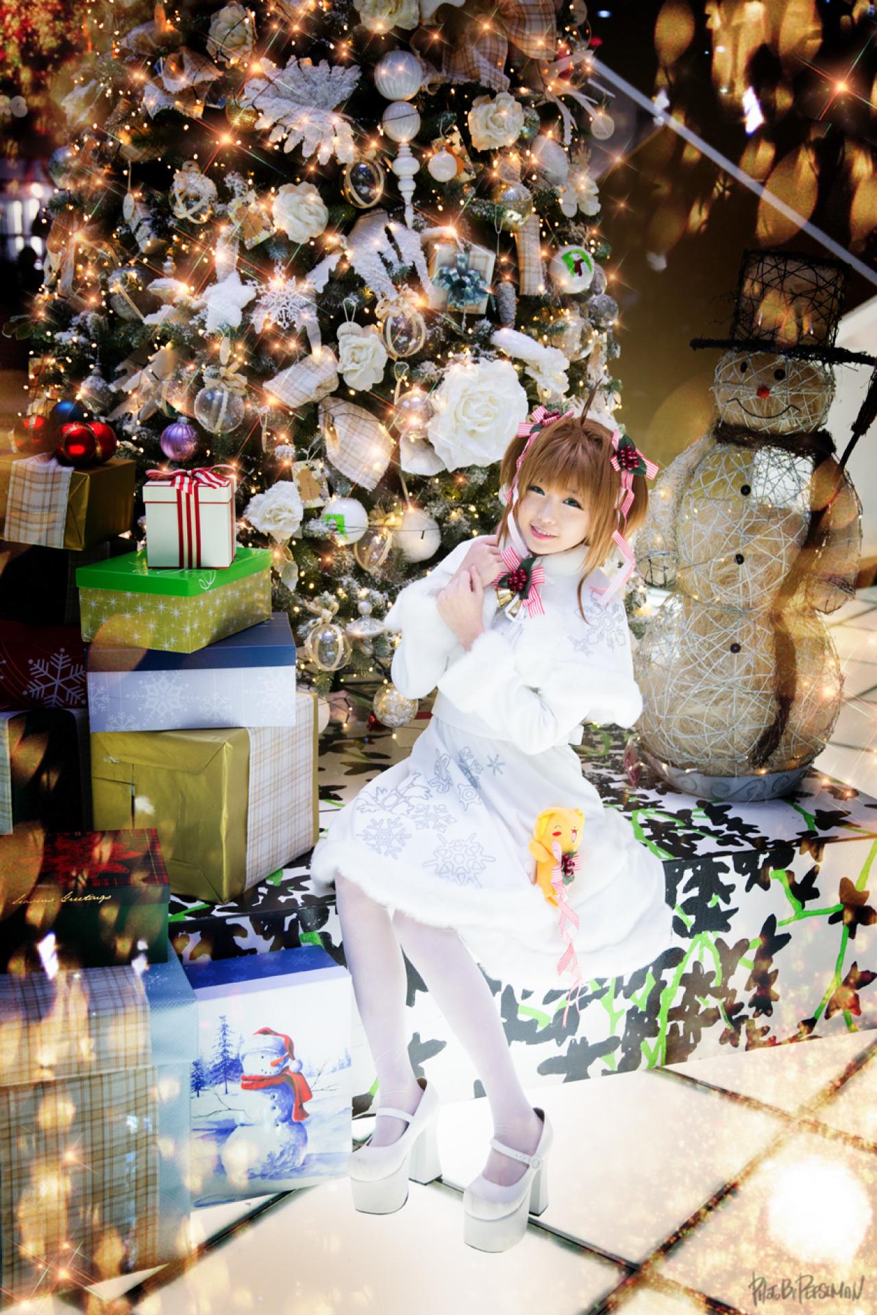 tomia兔娘扮木之本樱坐在圣诞树前，双手放在胸前，微笑