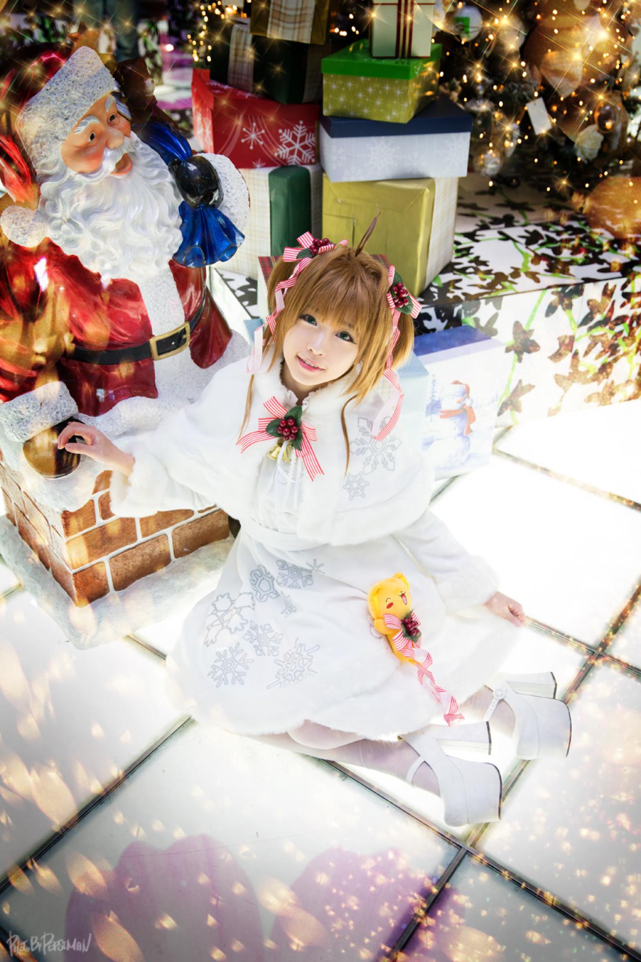 tomia兔娘扮木之本樱坐在地板上，右手搭在圣诞老人的手心上