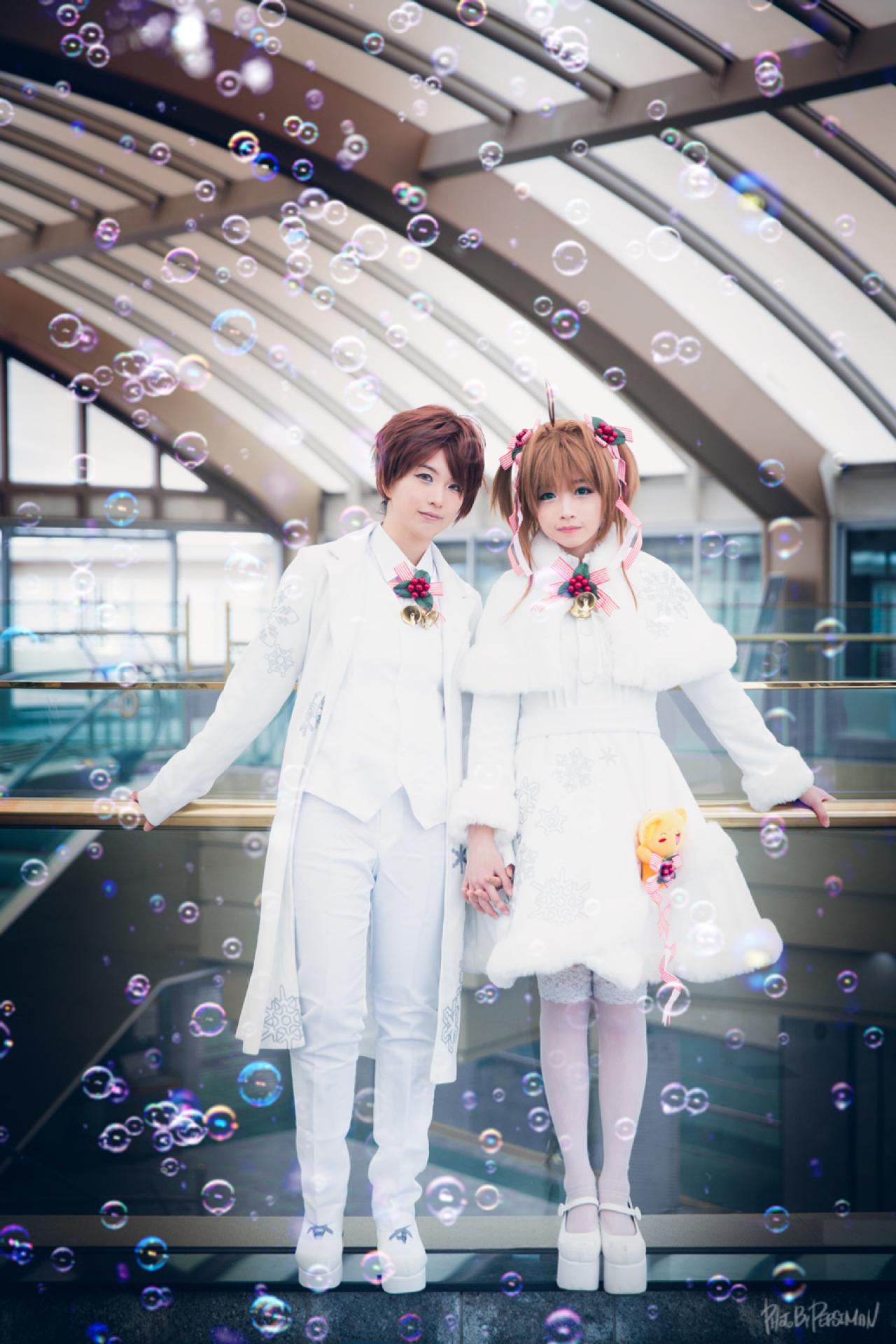 유화扮李小狼和tomia兔娘扮木之本樱扶着栏杆，手拉手站在一起