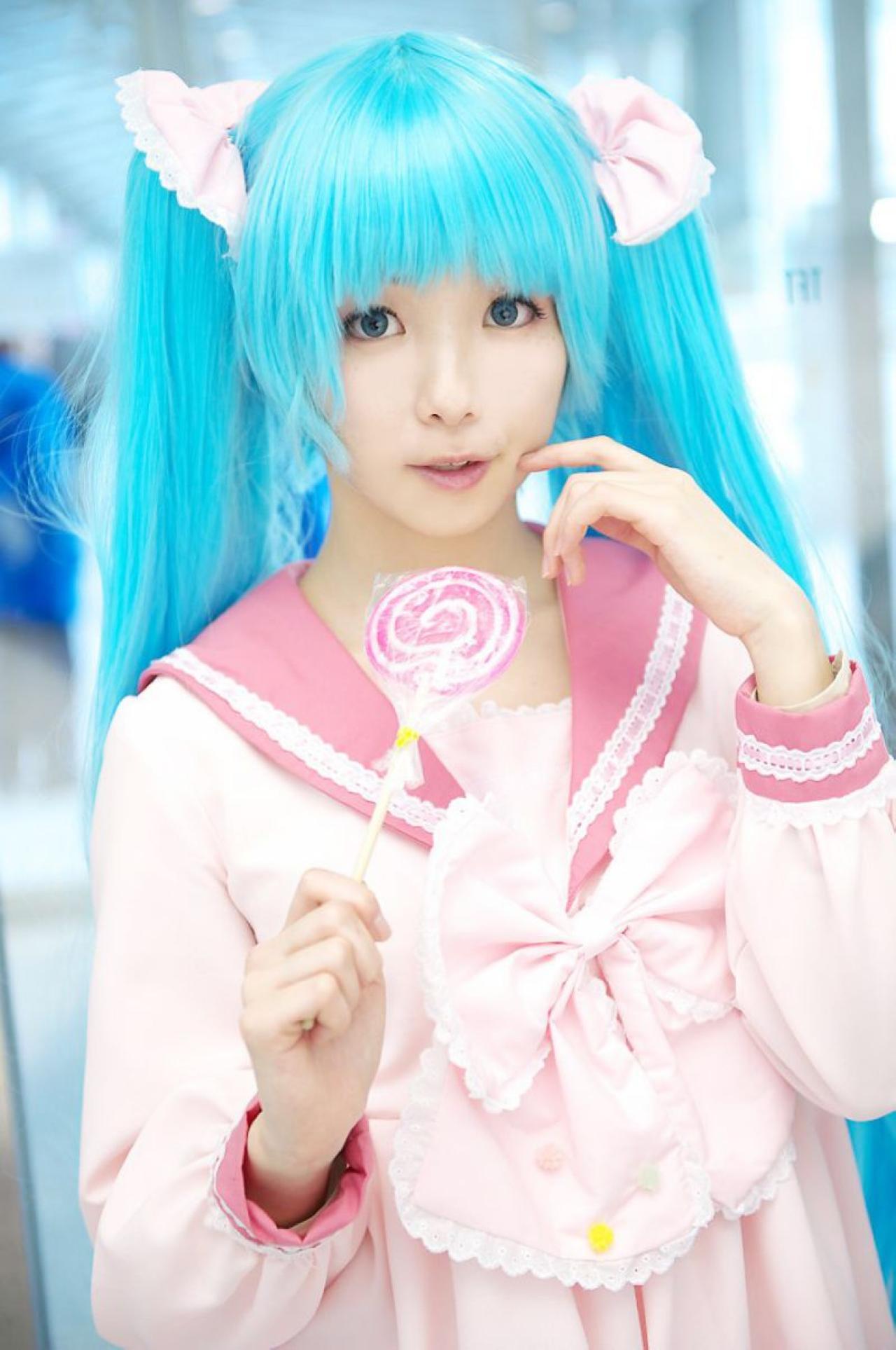 雪林檎扮初音未来右手拿着棒棒糖，左手戳脸