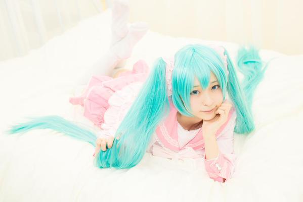 猫守ざーにゃ扮初音未来扒在床上，左手撑着下巴，右手抓着马尾