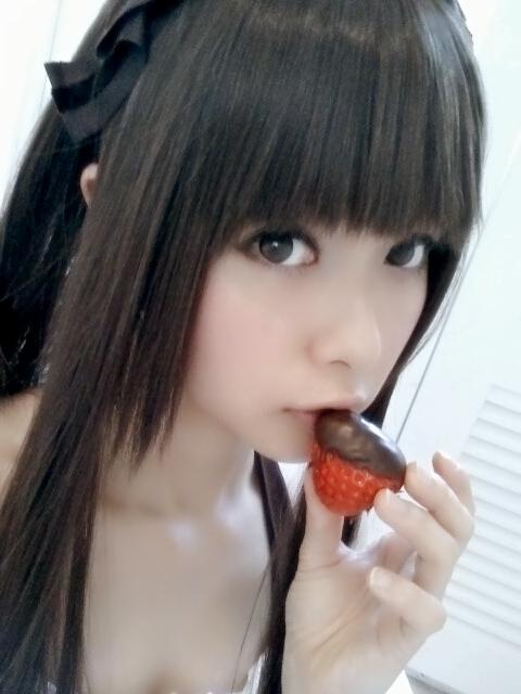 とめと拿着蘸着巧克力的草莓，贴在嘴边