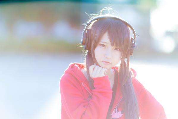 あんにゅい豆腐戴着耳机，左手撑着下巴，逆光正面照