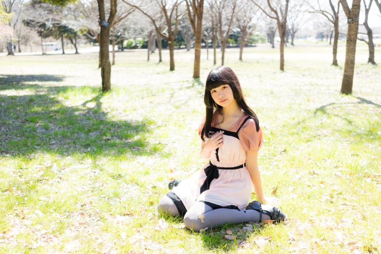 紺乃あすた跪坐在草地上，右手撑地，左手放在胸前