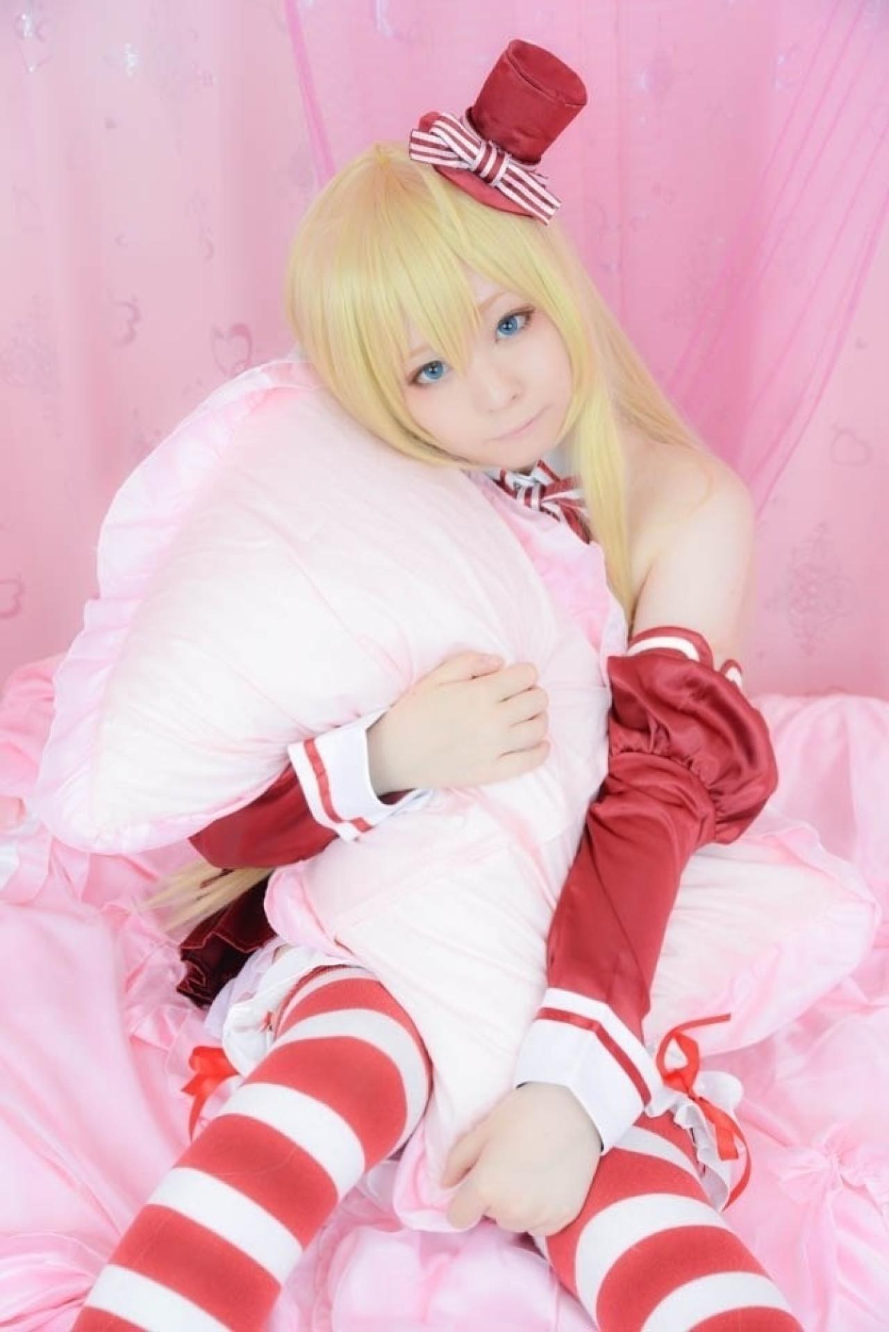 スイ扮裘可拉双手怀抱着枕头，坐在床上