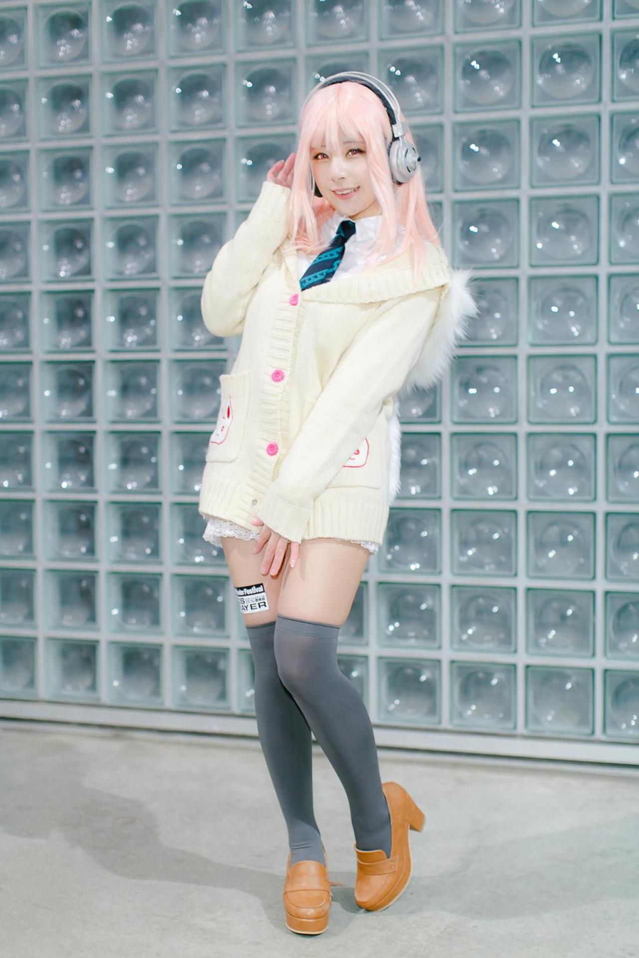 です扮超级索尼子右手扶着耳机，站姿