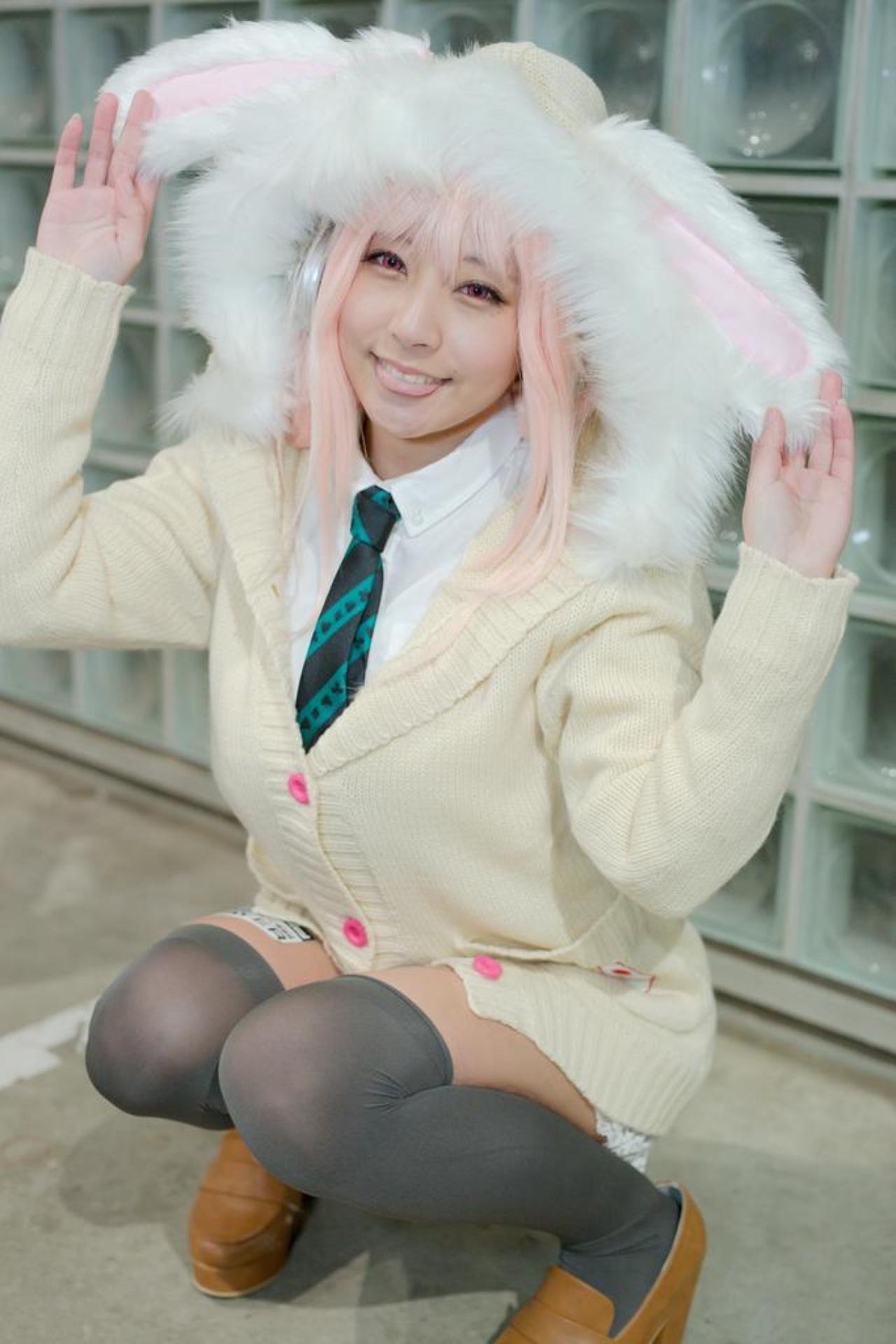 です扮超级索尼子双手抓着兔耳朵，吐舌卖萌，蹲姿