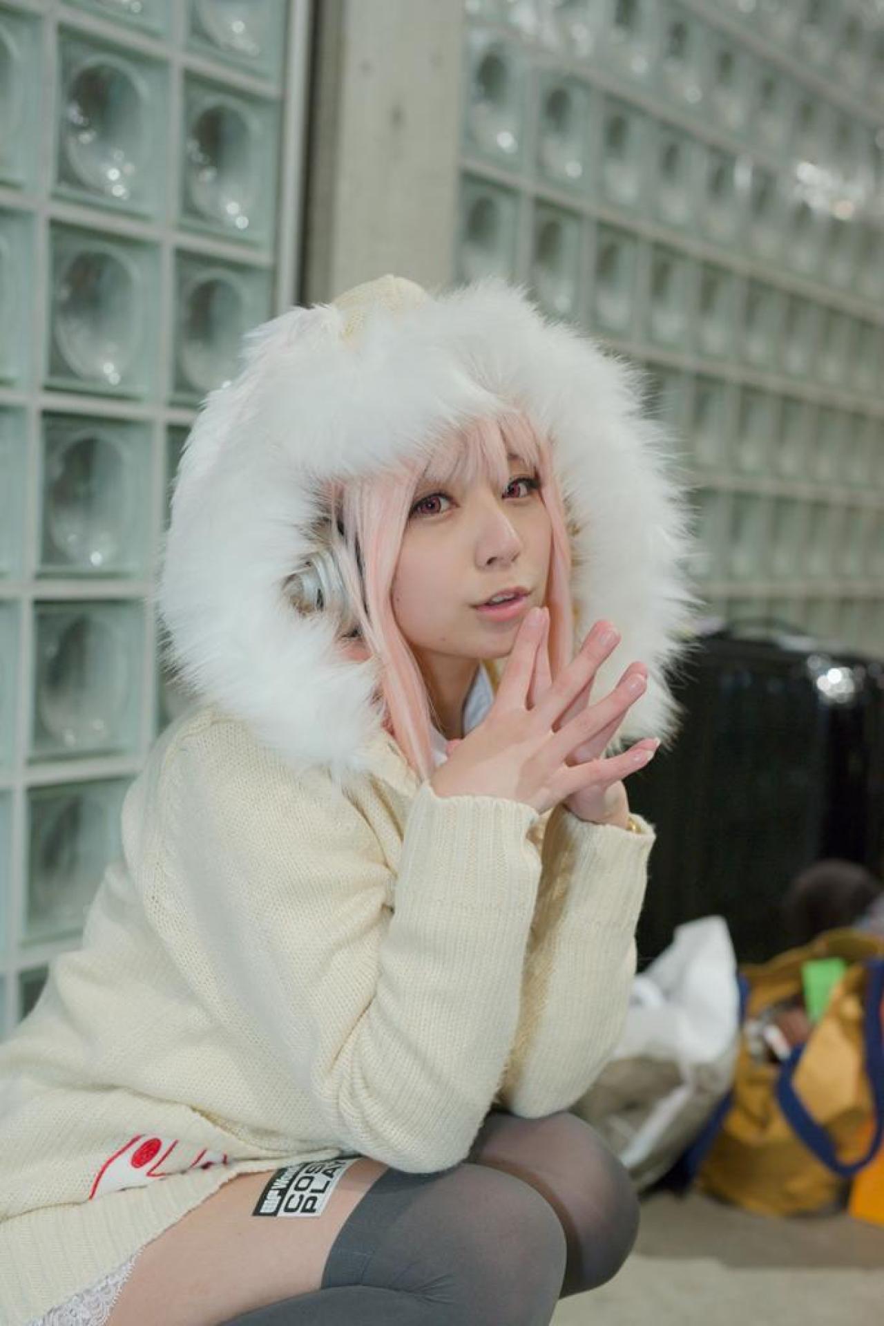 です扮超级索尼子双手五指相扣，贴着下巴，蹲姿