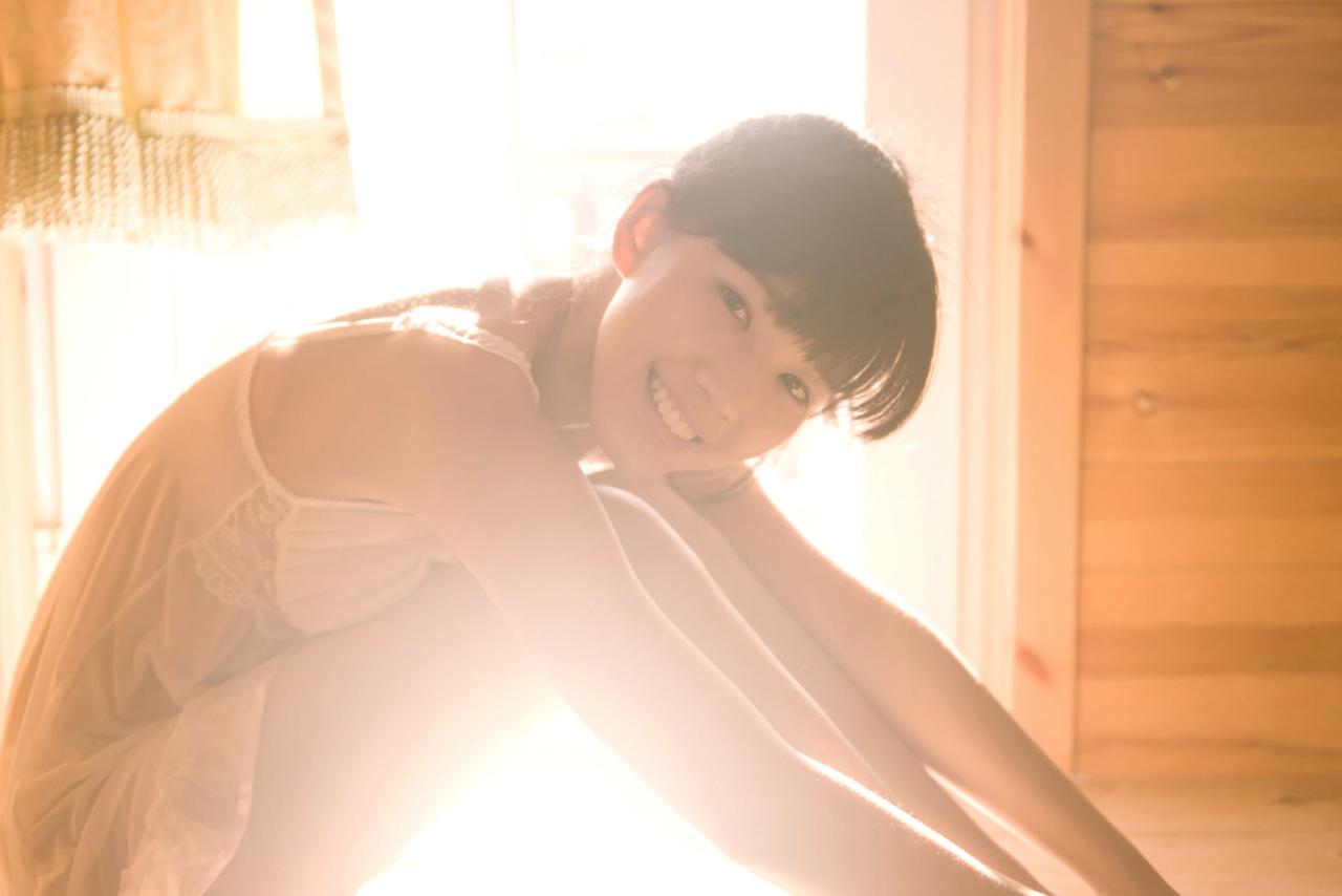 萌宅女蜷缩着身子，侧身坐在窗前