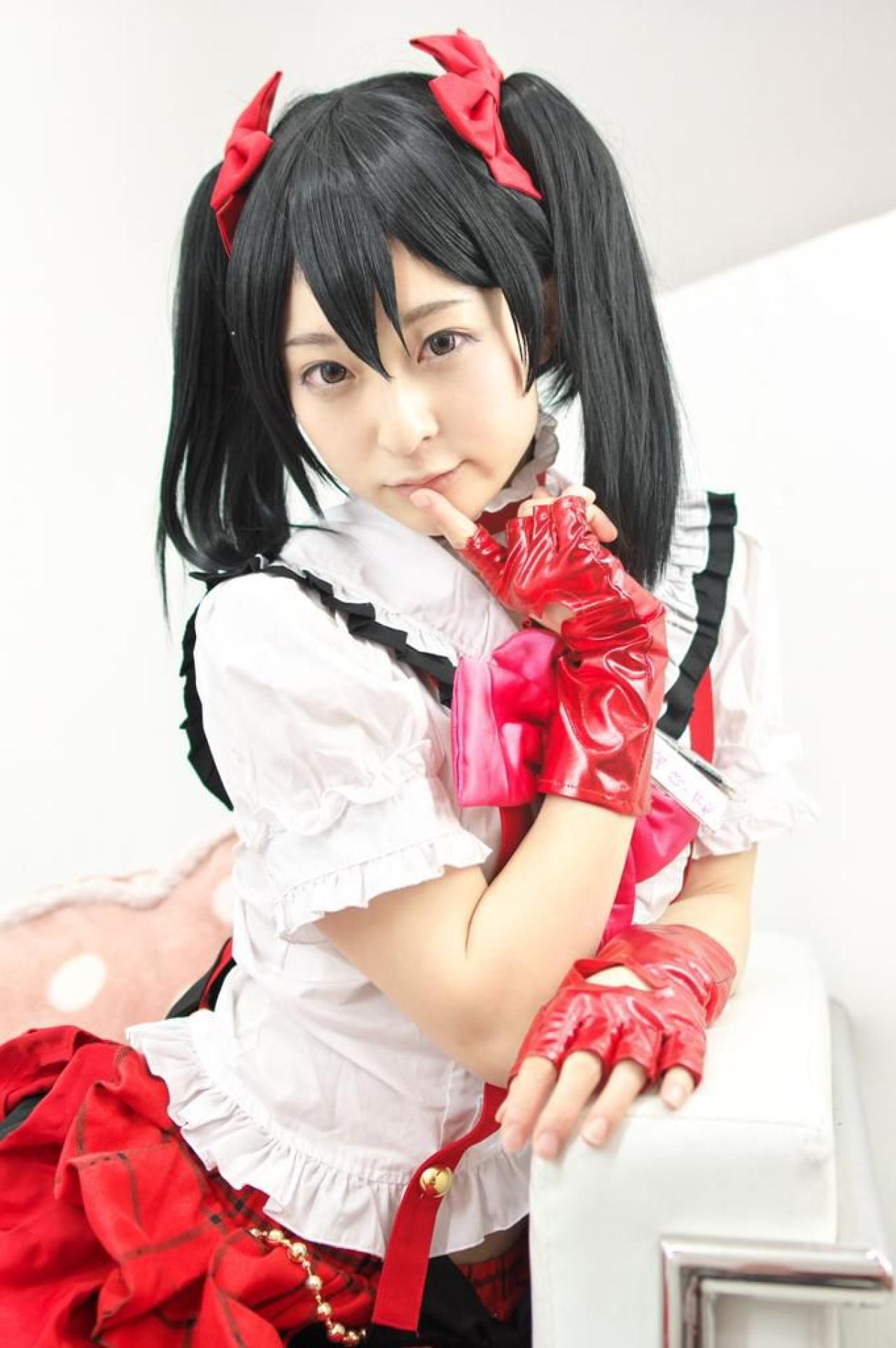 猫守ざーにゃ扮矢泽妮可扒在沙发的扶手上，作嘘手势