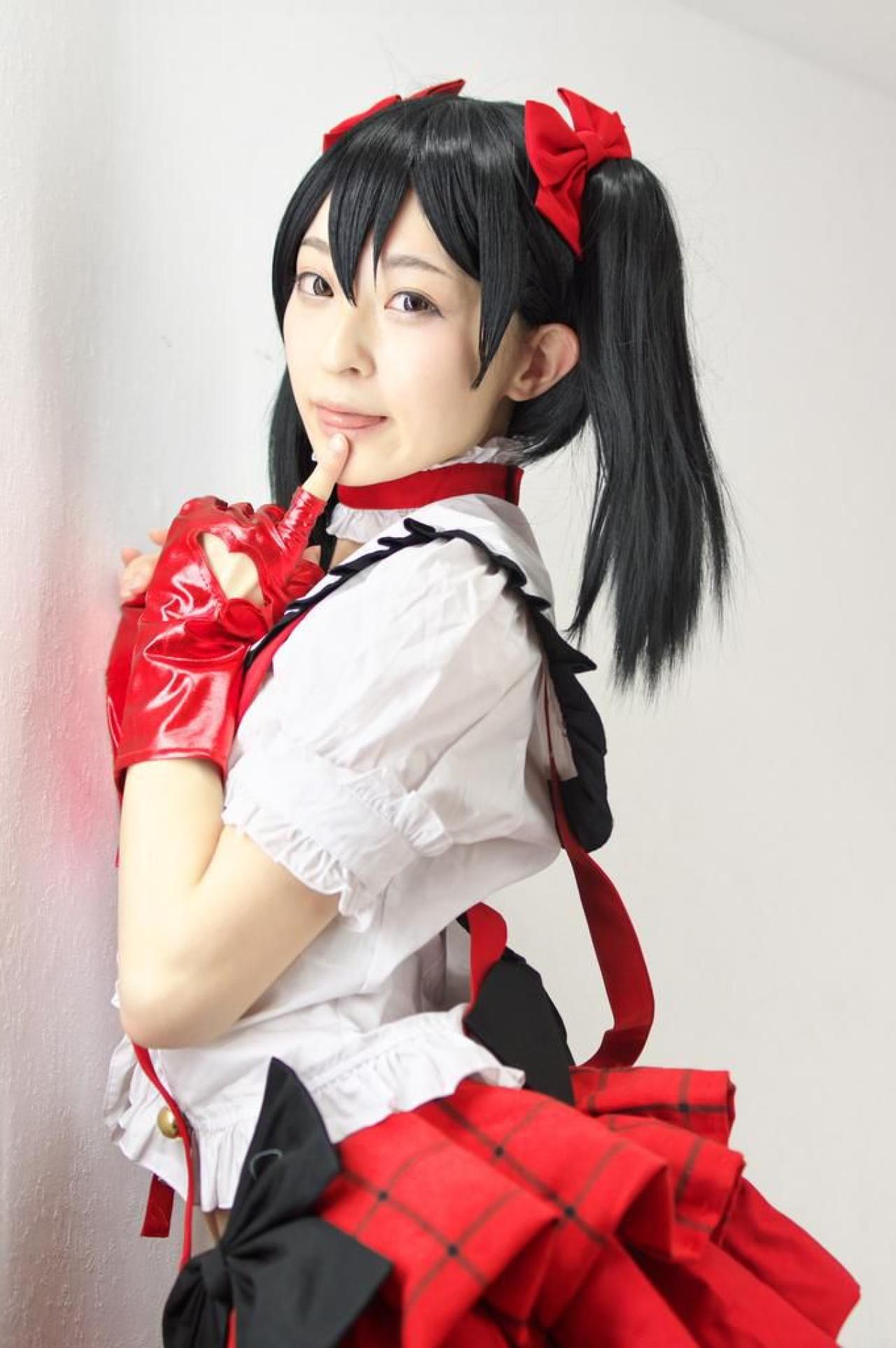 猫守ざーにゃ扮矢泽妮可右手扶着墙壁，左手食指抵着下巴，吐舌卖萌的侧面