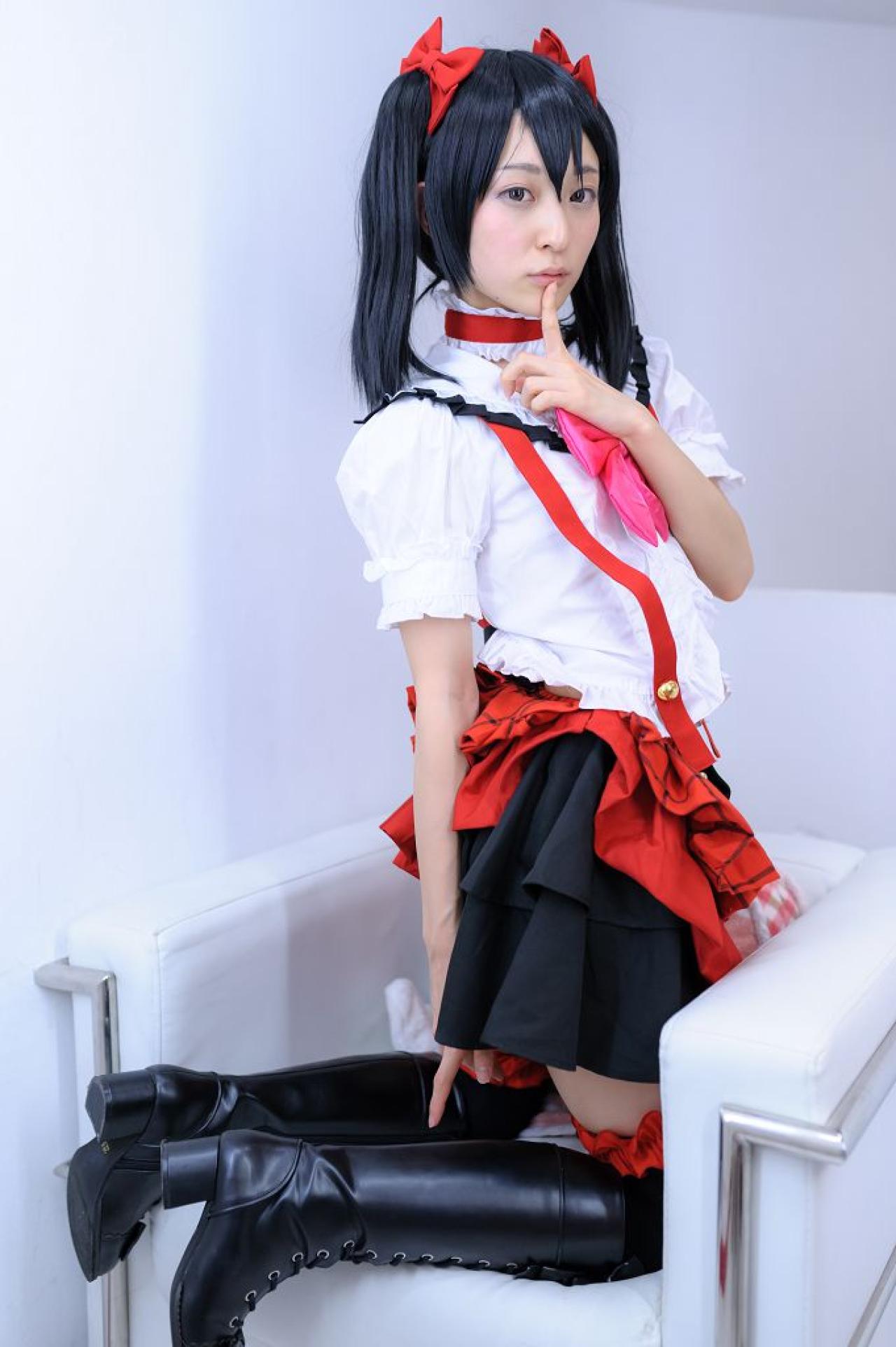 猫守ざーにゃ扮矢泽妮可跪坐在沙发上，嘟嘴作嘘手势