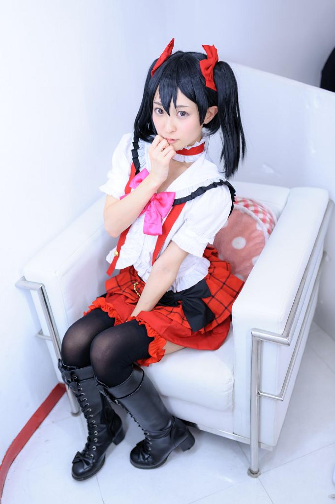 猫守ざーにゃ扮矢泽妮可坐在沙发上，右手半握拳贴着下巴