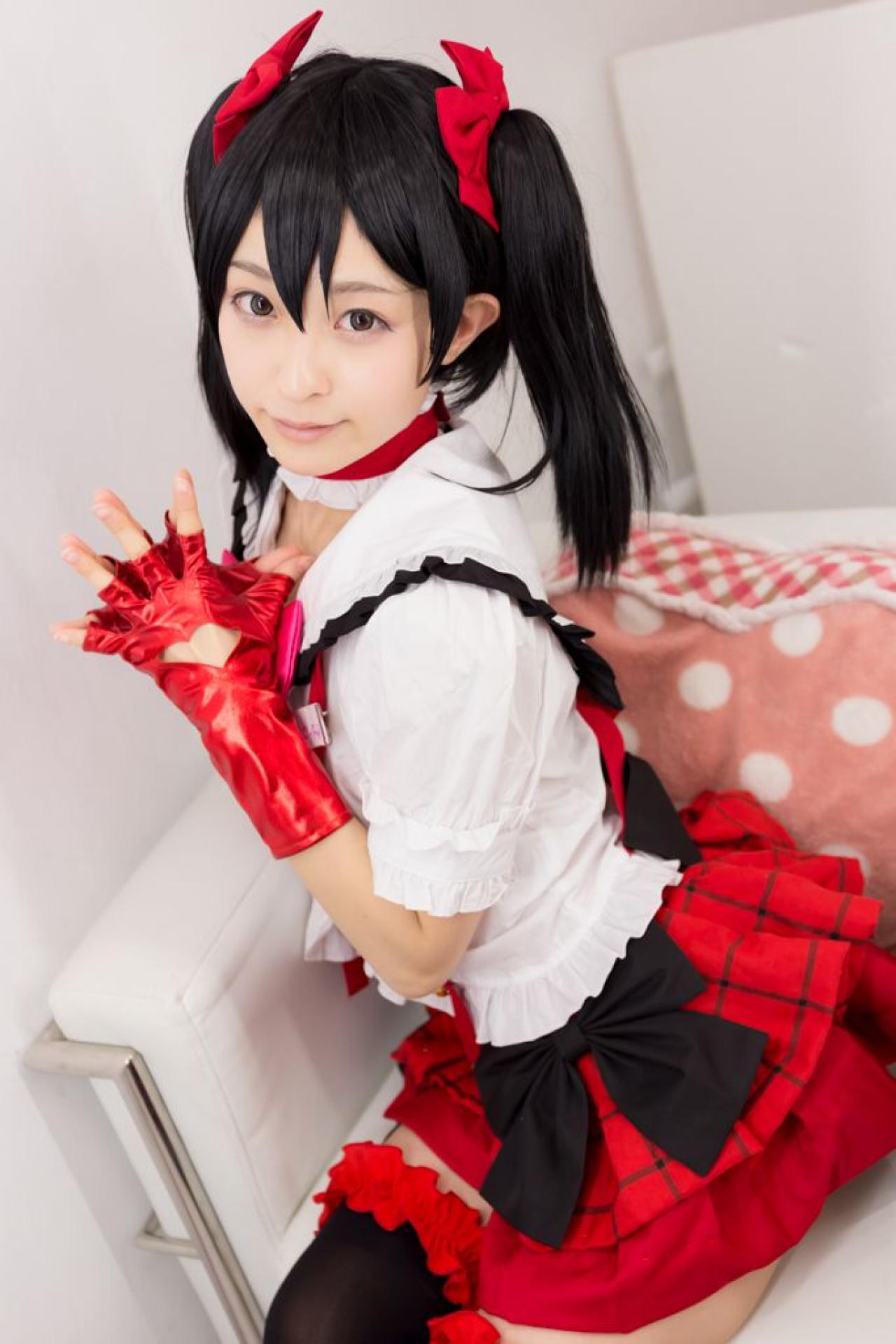 猫守ざーにゃ扮矢泽妮可双手五指张开贴在一起，坐在沙发上的侧面