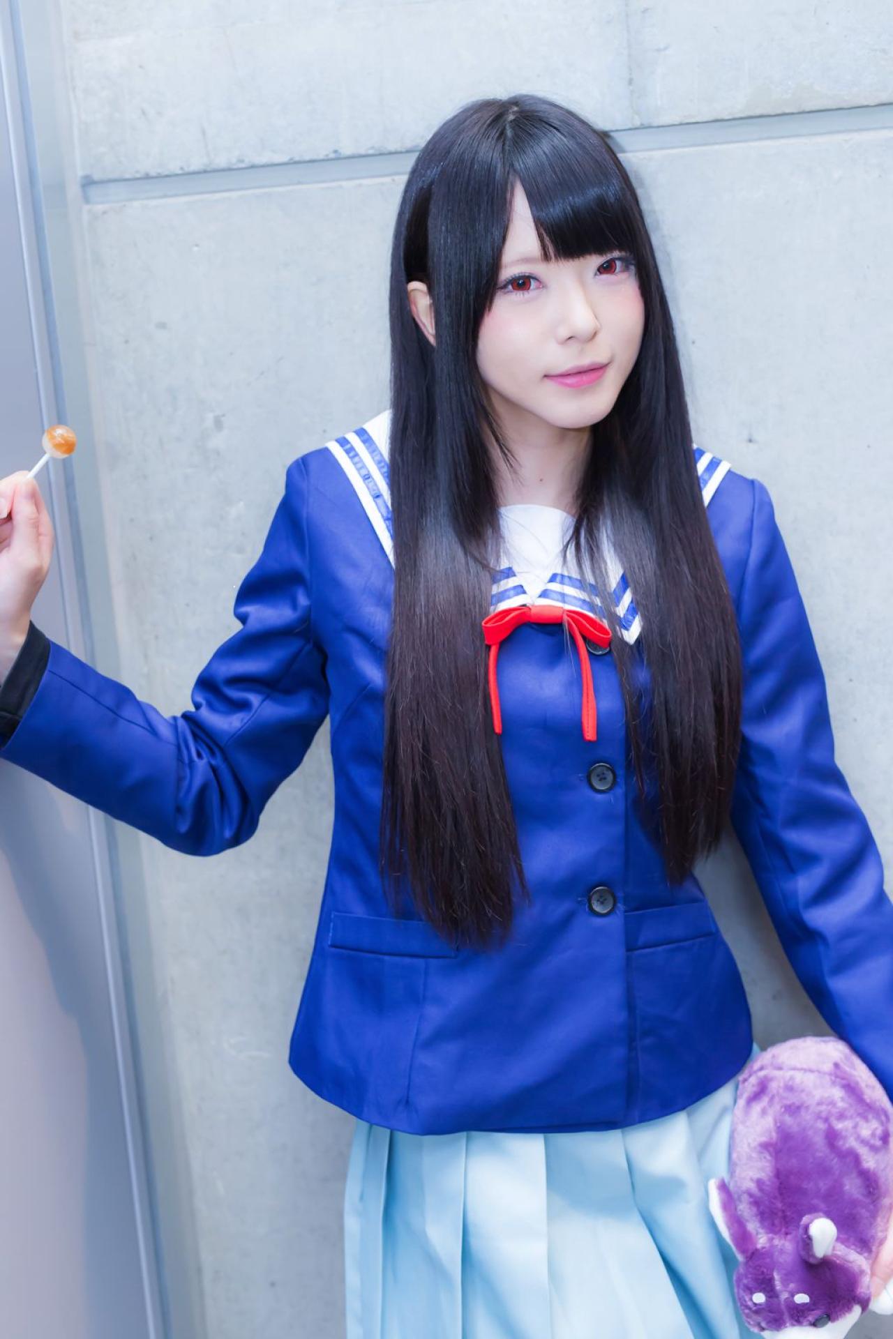 雪瀬ハル扮名濑美月，左手抱着烤番薯布偶，右手拿着棒棒糖