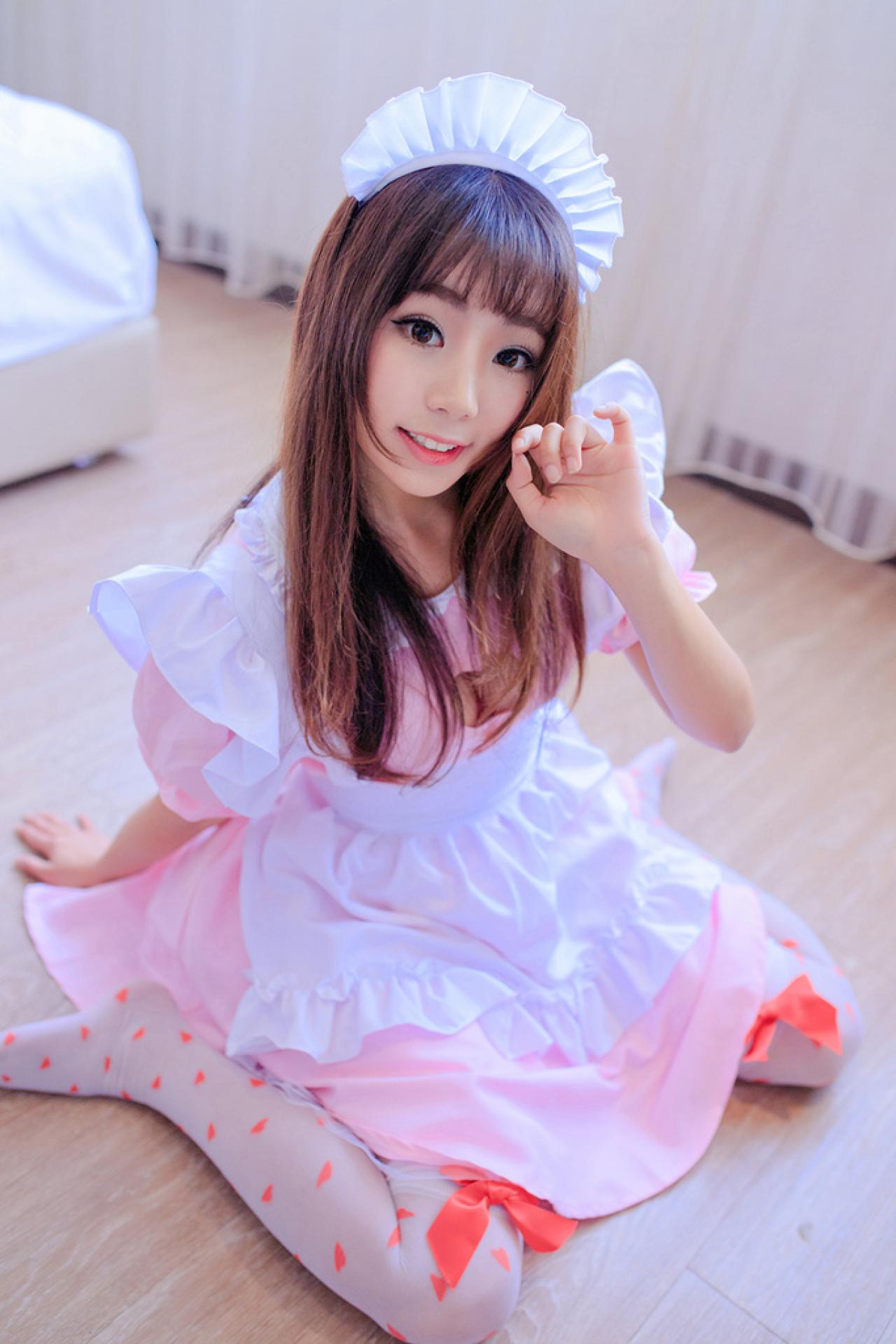 小灵跪坐在地板上，右手撑着地面，抬起左手轻贴着发梢