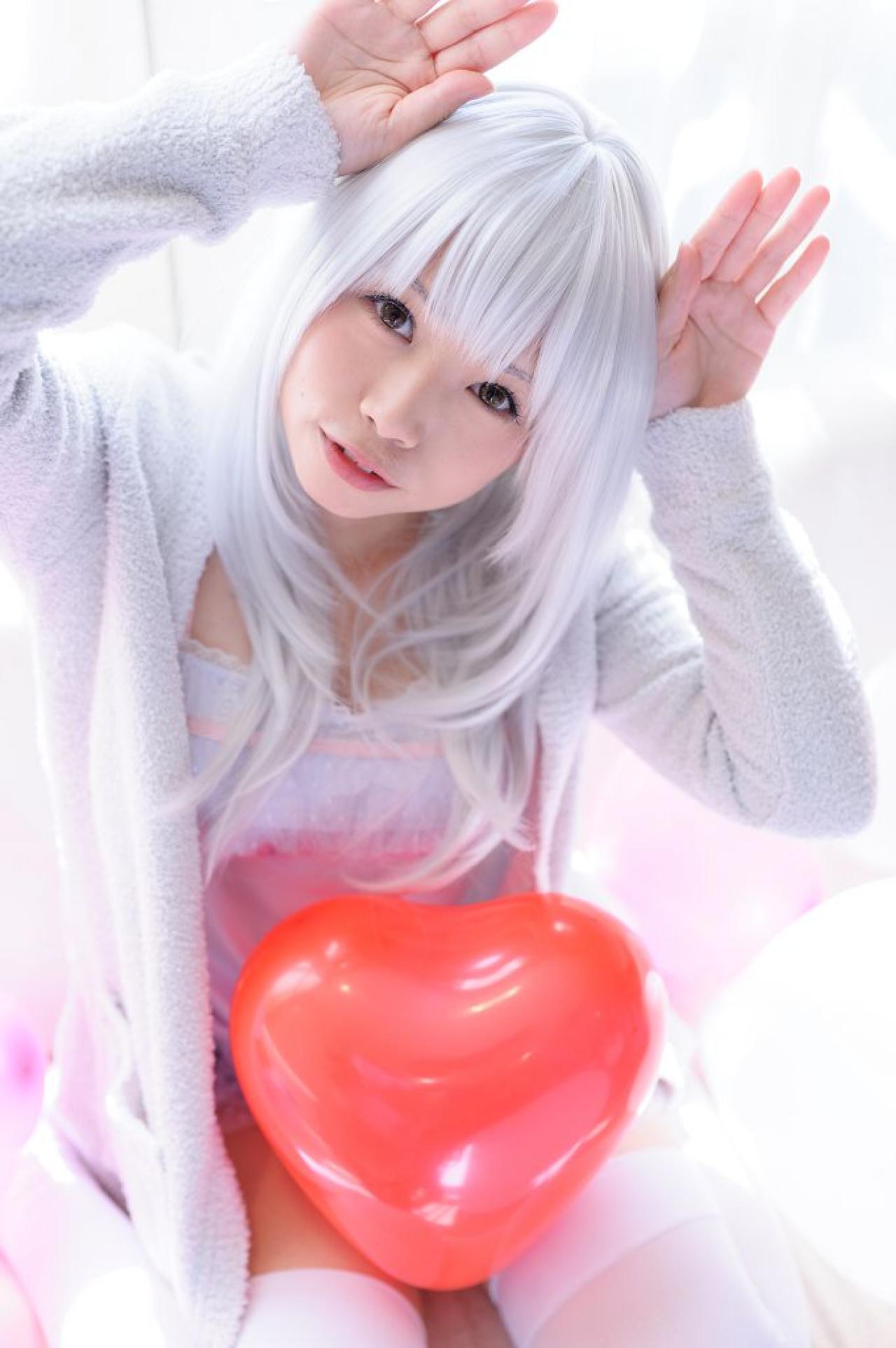 红色桃心气球放在膝盖上，yui双手搭在头发两侧，作兔耳卖萌