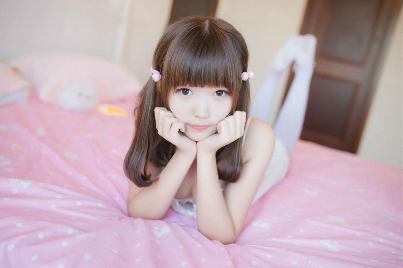 年糕颗颗颗双手撑着下巴扒在床上 正面照